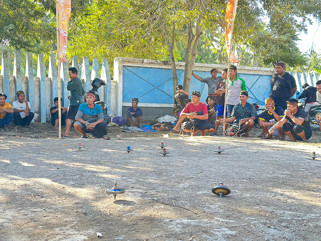 BERDEBAR: Sejumlah pemain gasing saat melihat gasing mereka yang berputar di arena Begasingan di areal pantai Sunrise Land Lombok pada saat pra turnamen. (SUPARDI/LOMBOK POST)