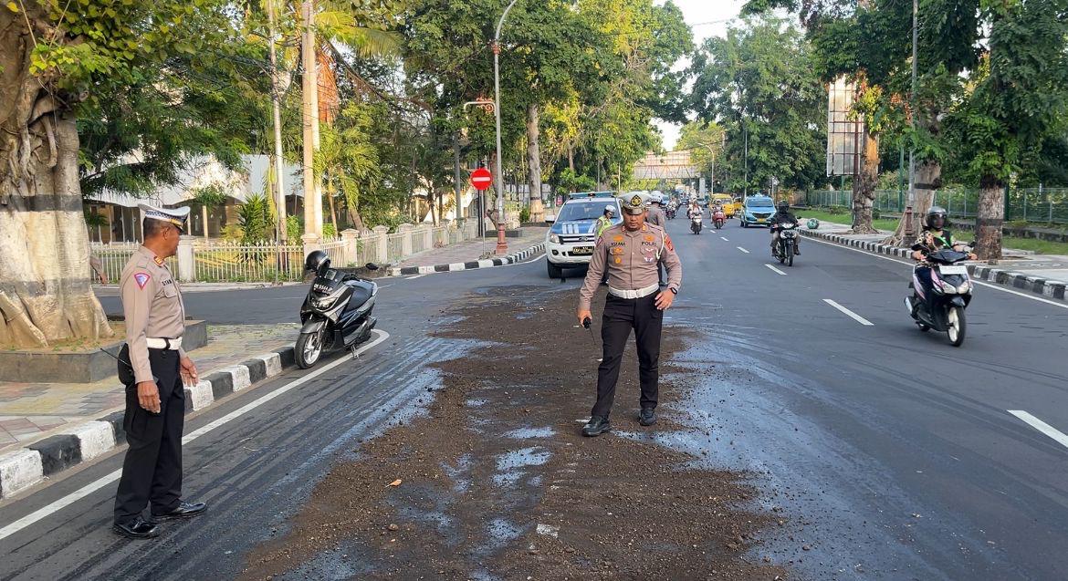 MEMBAHAYAKAN: Kasatlantas Polresta Mataram mengerahkan anggota menimbun bekas oli yang tumpah di Jalan Langko Mataram samping Masjid Hubbul Wathan Islamic Center Mataram. (DOK SATLANTAS POLRESTA)