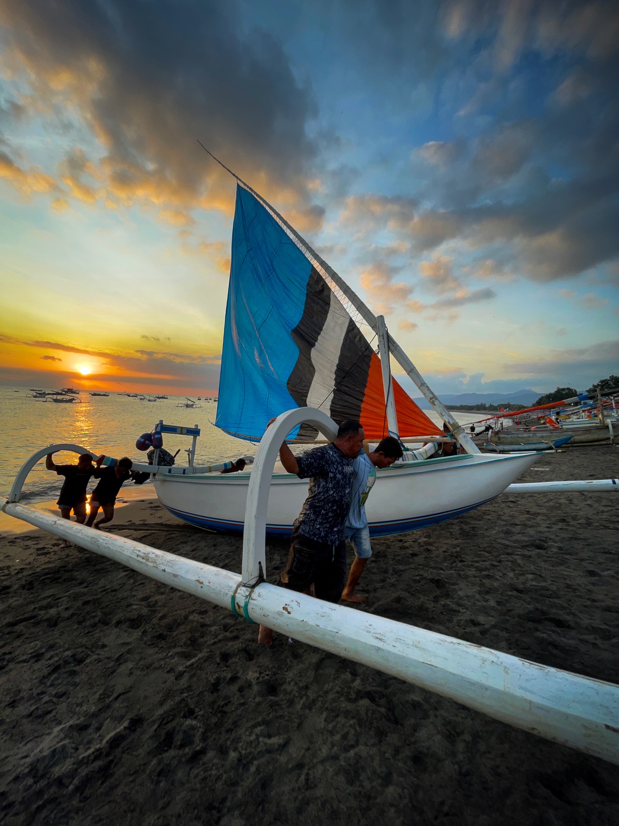 MENCARI NAFKAH: Nelayan saling bahu membahu menarik perahu ke daratan, karena bertambah berat akibat muatan ikan yang ditangkap selama melaut. (FOTO: IVAN/LOMBOK POST)  &nbsp;
