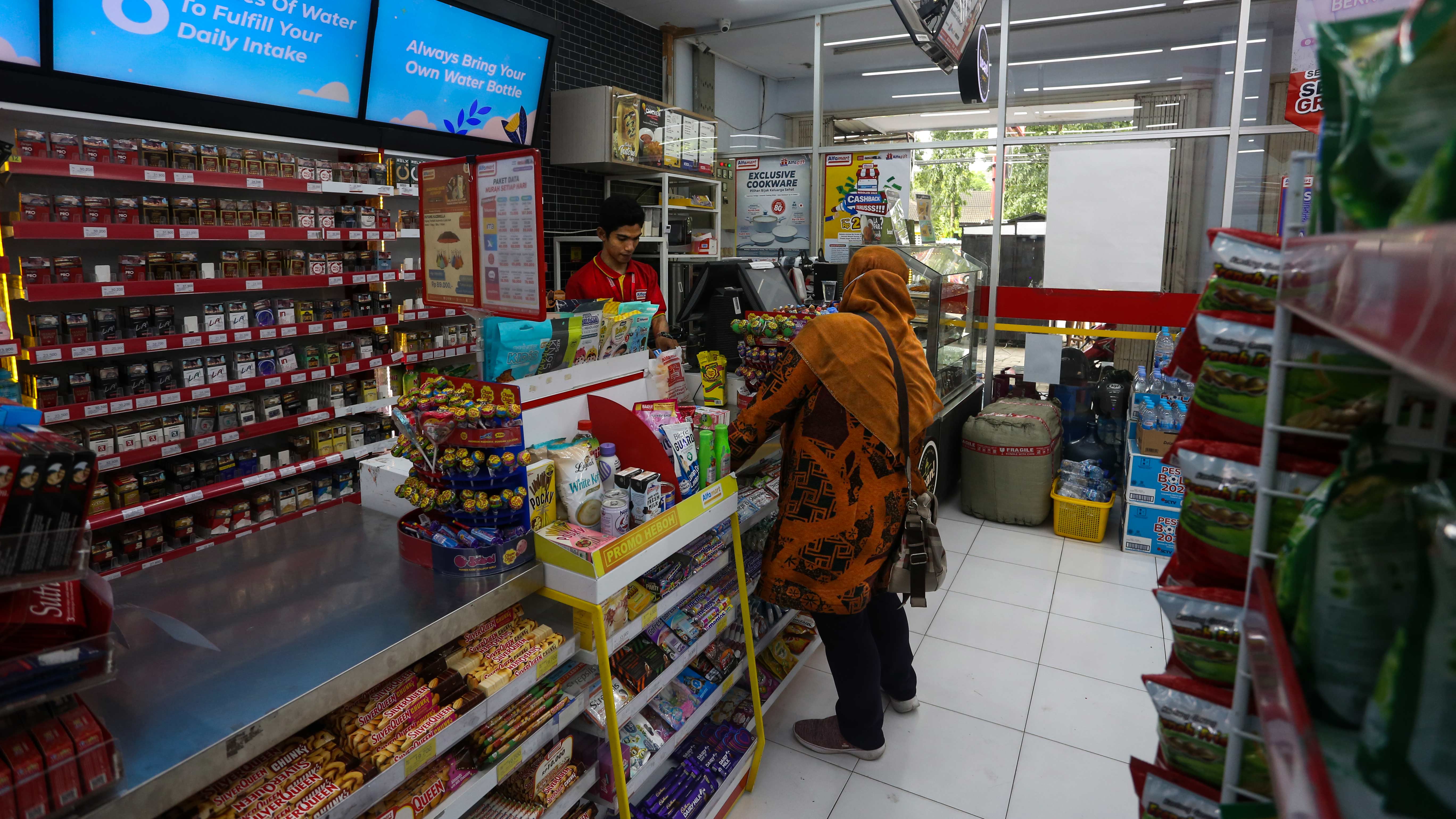 JANGAN GUNAKAN KANTONG PLASTIK: Pegawai Alfamart melayani pembeli saat membayar barang belanjaannya, kemarin (21/7). (IVAN/LOMBOK POST)
