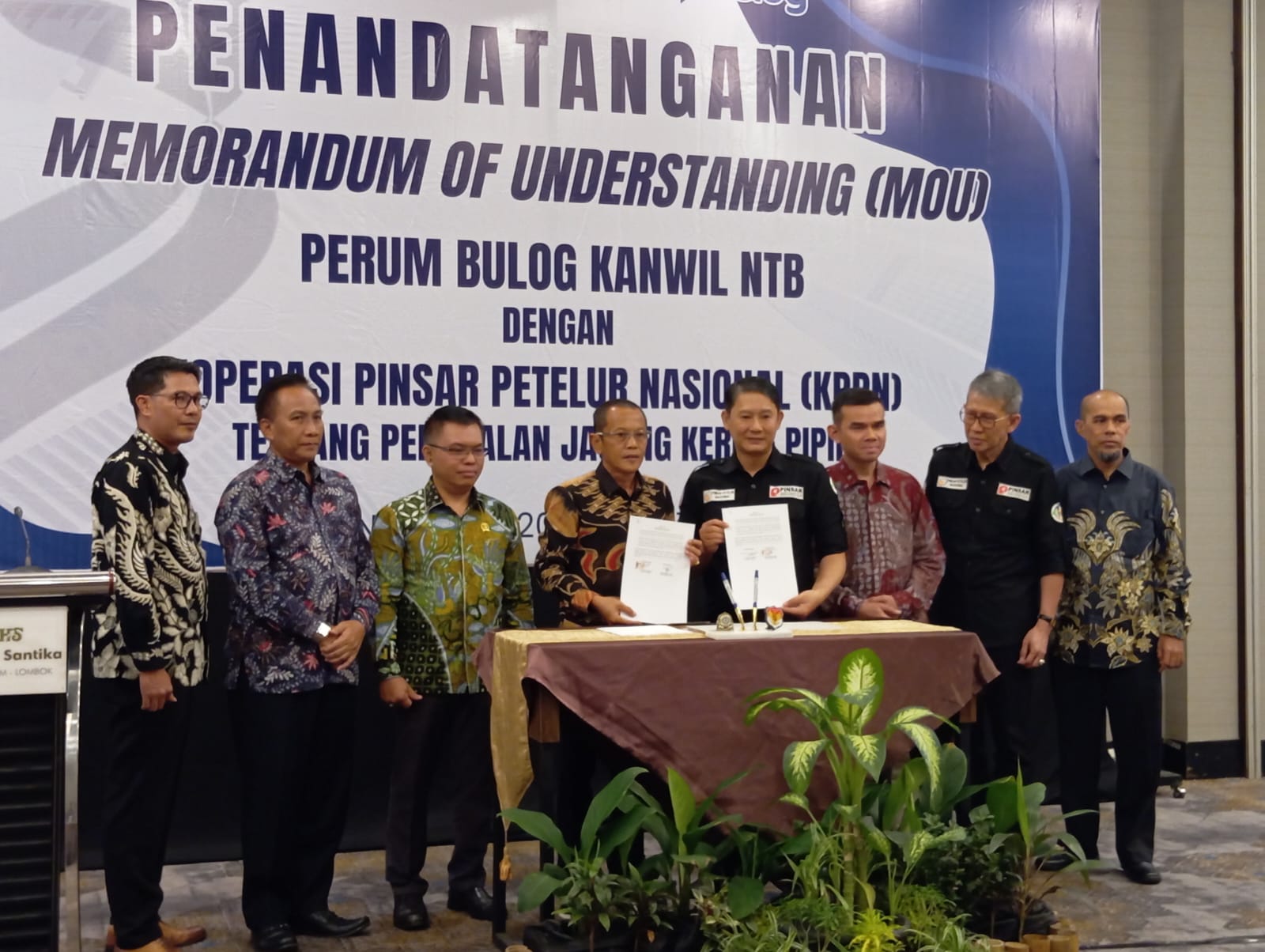 KERJA SAMA: Pimwil Bulog NTB Raden Guna Dharma (empat kiri) dan Ketua Presidium Koperasi Pinsar Petelur Nasional (KPPN) Yudianto Yosgiarso (empat kanan) menunjukkan nota kesepahaman MoU, Senin (22/7).