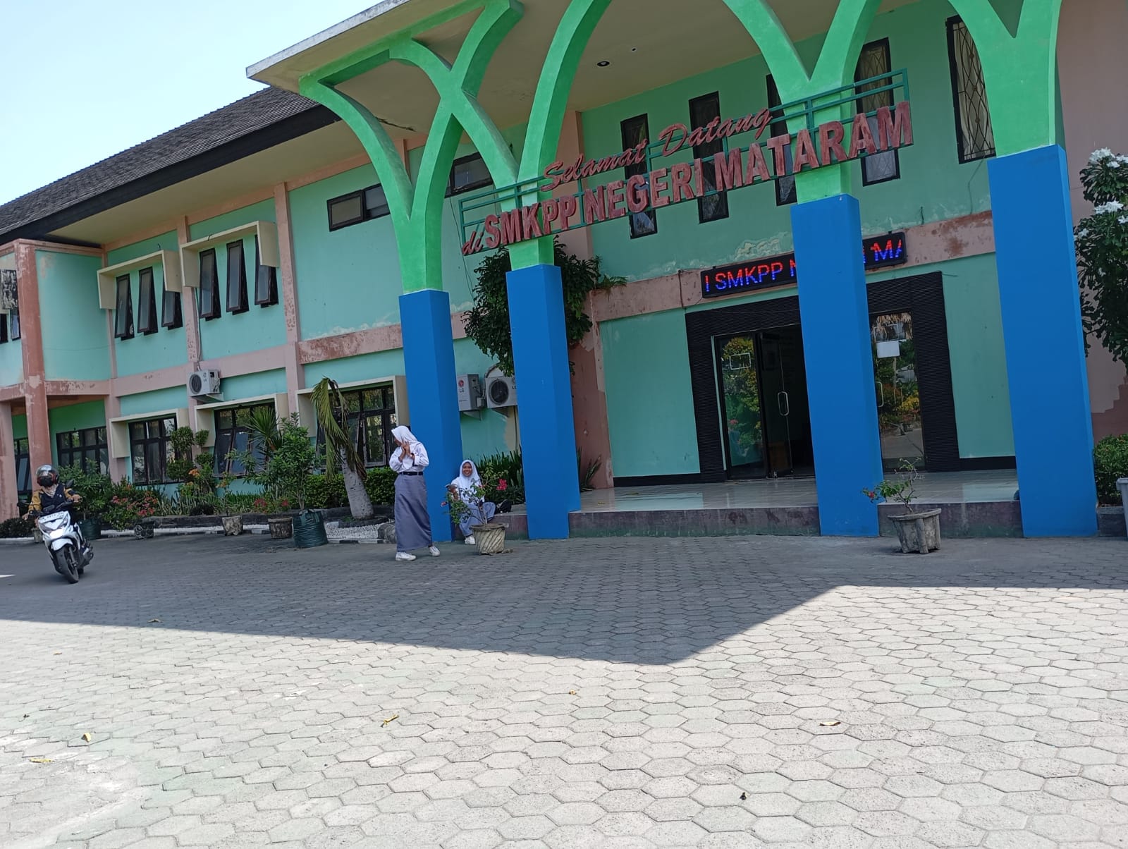 TUNGGU JEMPUTAN: Dua orang siswa SMKPPN Mataram menunggu jemputan saat jam pulang di sekolah setempat, kemarin (23/7).(ROJAI/LOMBOK POST)