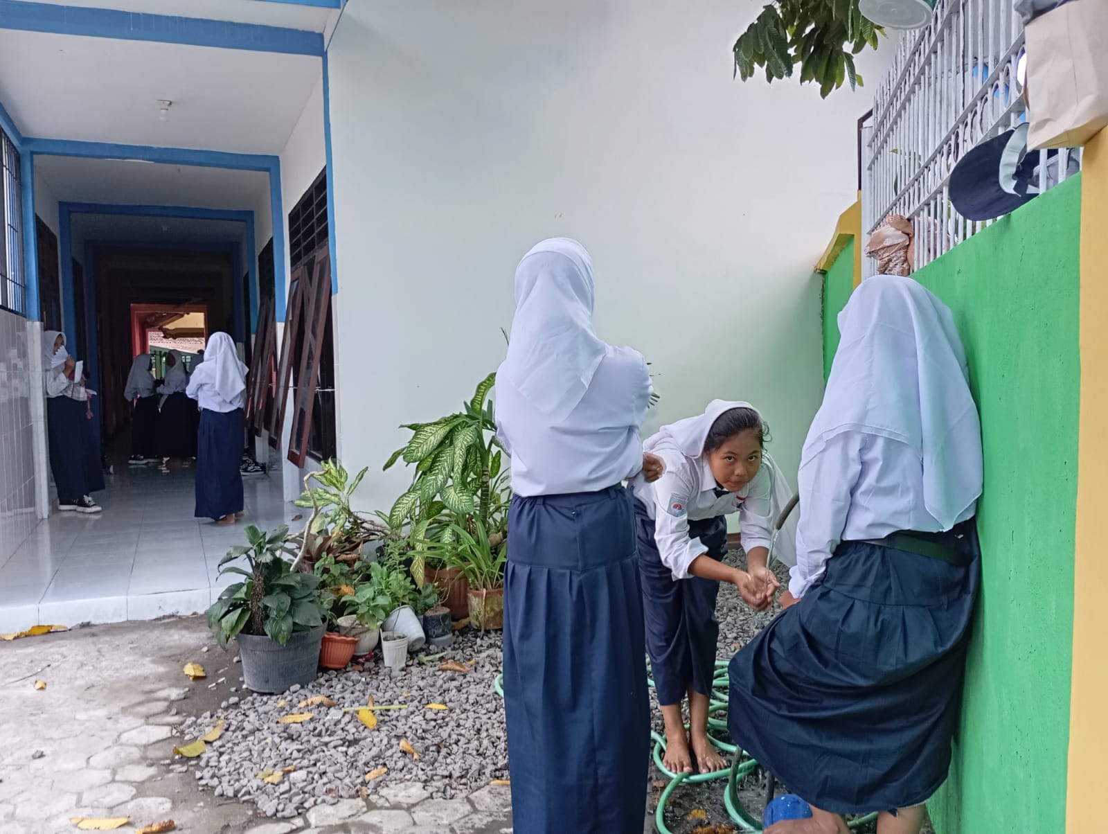 JALANKAN IBADAH: Tiga siswa SMPN 19 Mataram berwudhu di halaman sekolah setempat, kemarin (23/7). (ROJAI/LOMBOK POST)