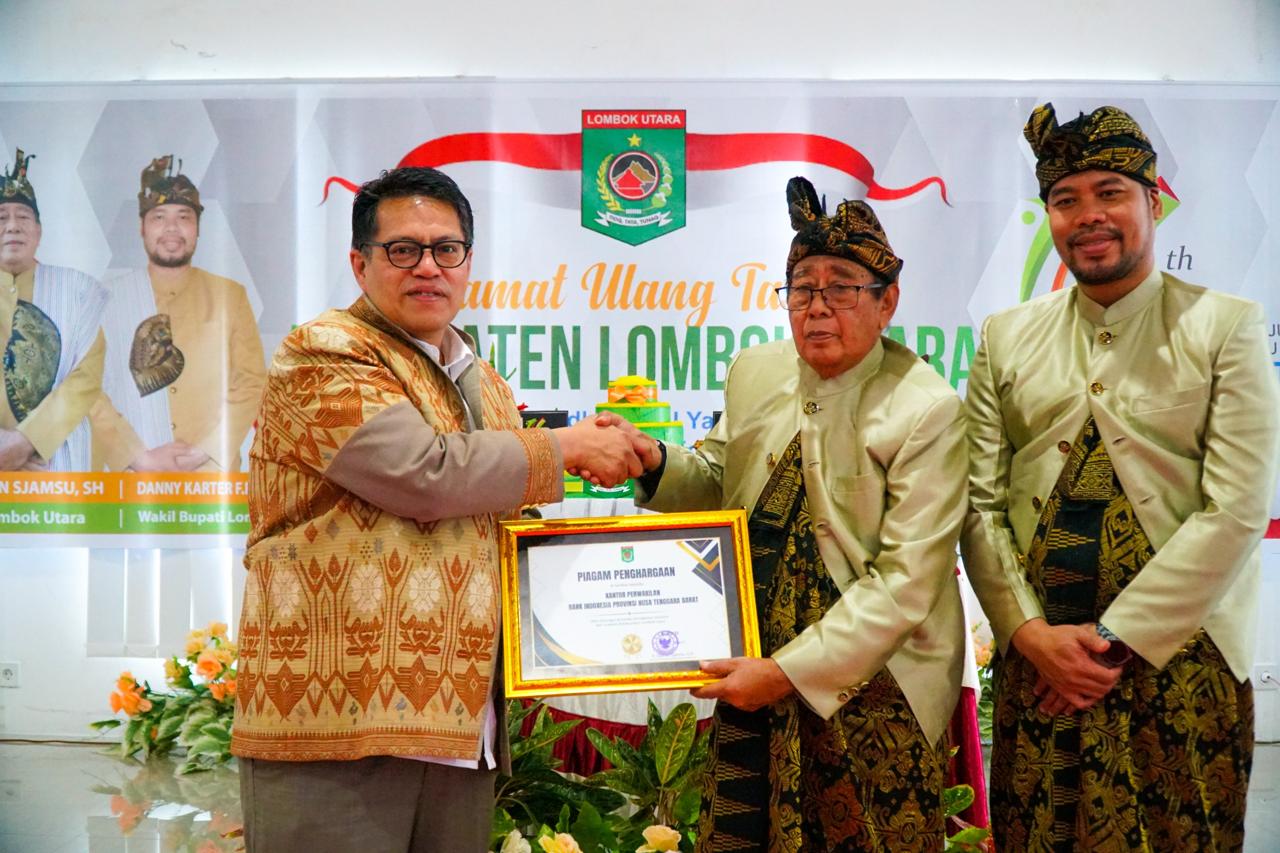 TERIMA APRESIASI: Kepala Perwakilan Bank Indonesia NTB Berry Arifsyah Harahap (kiri) menerima penghargaan dari Bupati Lombok Utara Djohan Sjamsu (tengah) didampingi Wakil Bupati Danny Carter. (IST)