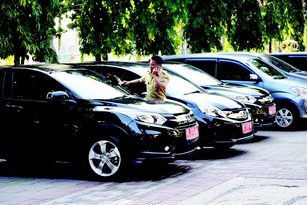 MASIH DIDATA: Pegawai berdiri diantara mobil dinas milik Pemkot Mataram di Kantor Wali Kota Mataram, beberapa waktu lalu.(DOK LOMBOK POST)