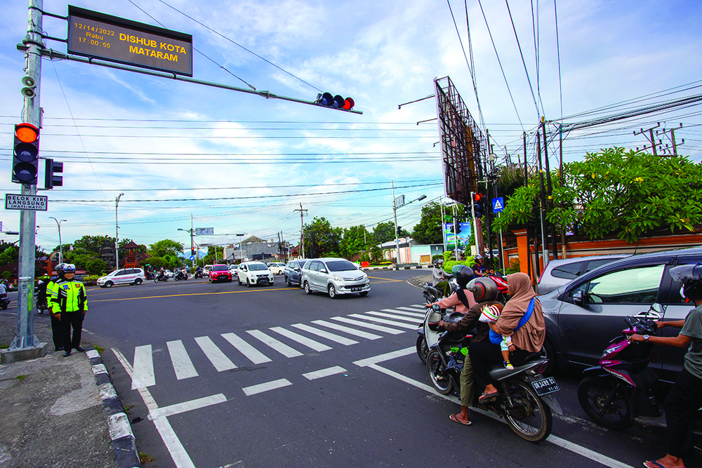 DIPANTAU KAMERA: Sejumlah pengendara menghentikan kendaraannya di lampu merah Tanah Aji, Mataram, kemarin (29/7). (IVAN/LOMBOK POST)