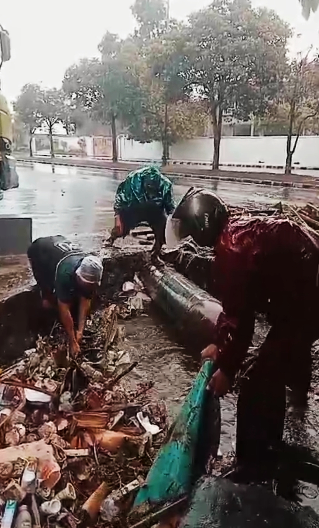 HINDARI BANJIR: Sejumlah petugas mengangkut sampah di selokan yang berada di Dasan Cermen, Kota Mataram, kemarin (30/7).(HARLI/LOMBOK POST)