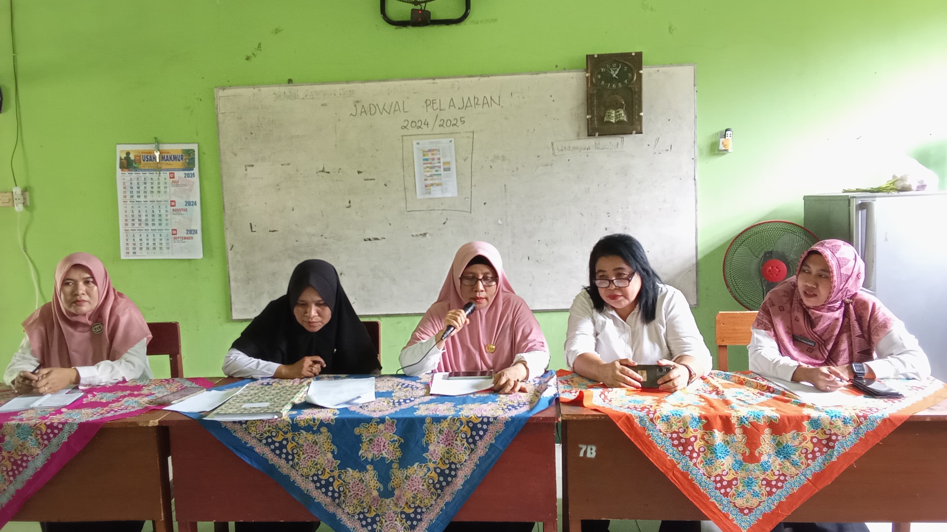 RAPAT: Plt Kepala SMPN 21 Mataram Hj Rohana Helmi (pegang mik) memimpin rapat persiapan STQ Pelajar Kota Mataram di sekolah setempat, kemarin (31/7).(SMPN 21 MATARAM FOR LOMBOK POST)