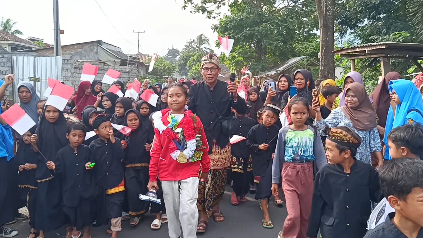 JUARA: Atlet silat Sirhandini Aslamiyah, yang berhasil meraih juara I pada kejuaraan IPSI tingkat nasional yang disambut puluhan siswa dan masyarakat sekitar, saat tiba di kampung halaman.