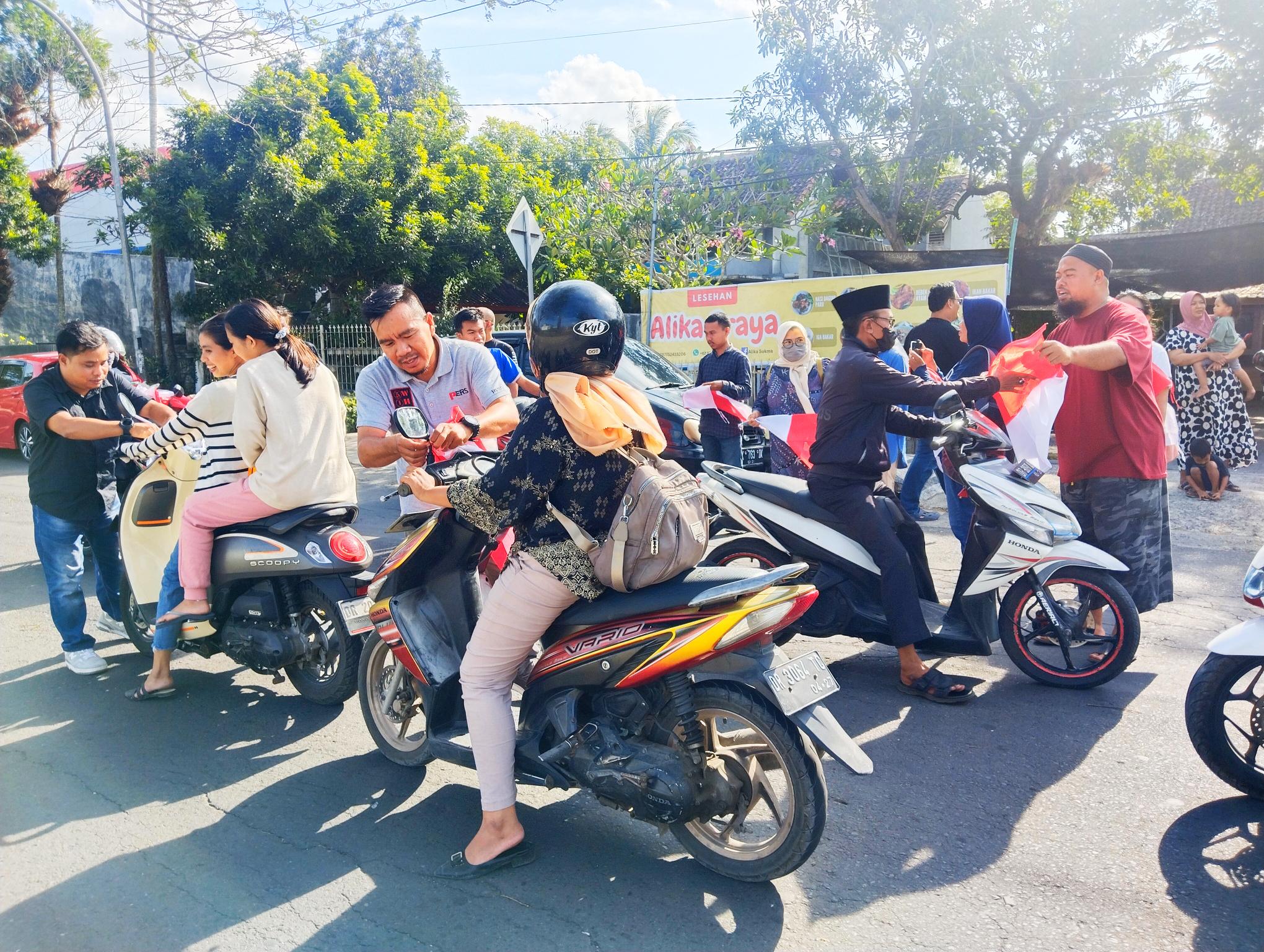 Suasana pembagian ratusan bendera merah putih kepada pengendara bermotor yang dilakukan PWLT di Kota Praya, Kamis (8/8).