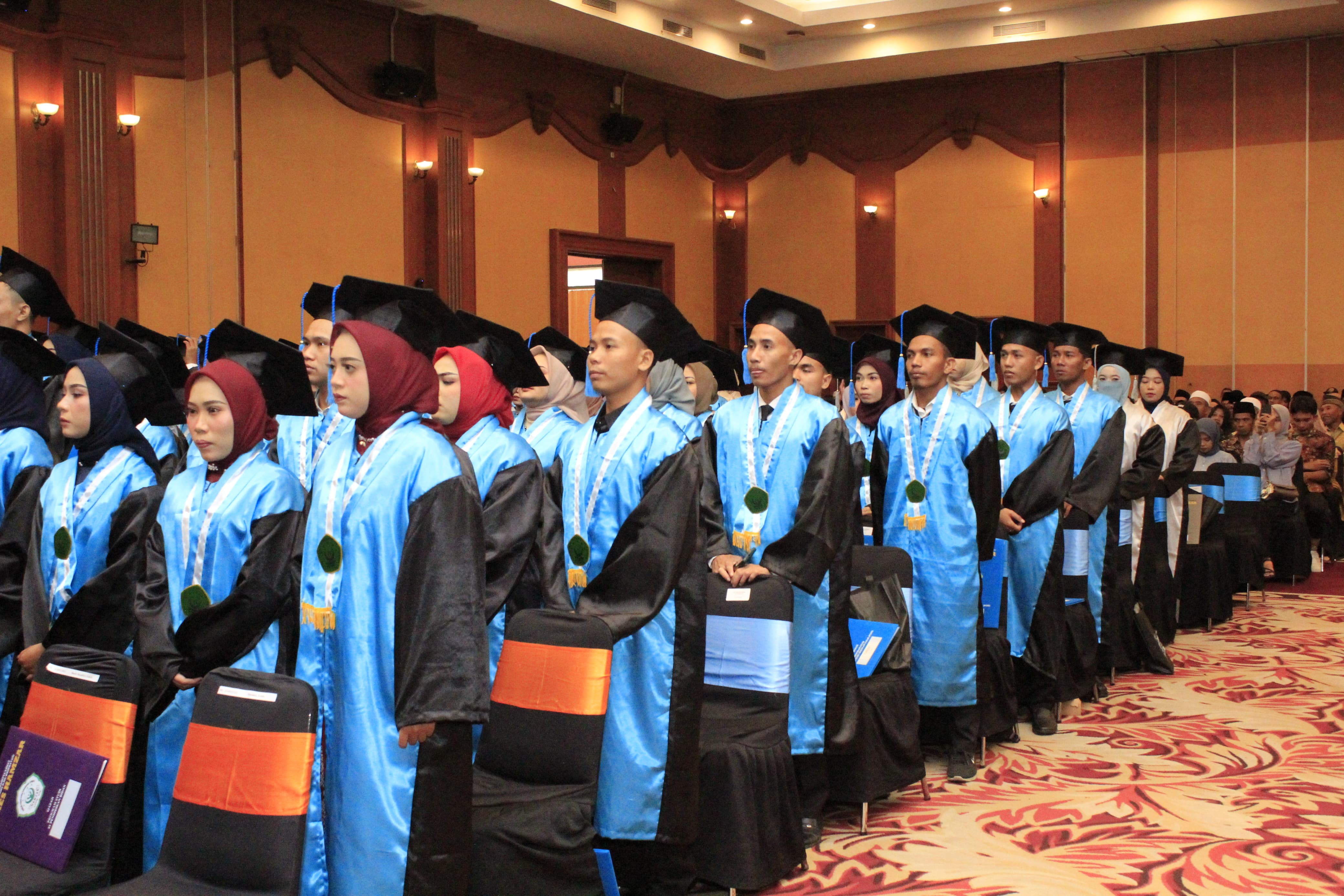 KHIDMAT : Para wisudawan dan wisudawati berdiri saat menyanyikan lagu kebangsaan Indonesia Raya.