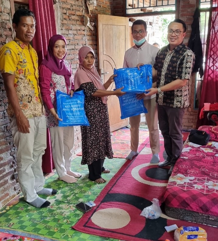 Ketua tim dari Bidang P2P Dinas Kesehatan NTB Lalu Simbawara, S.KM., M.Si (kanan) membagikan kelambu kepada warga di Kecamatan Plampang, Kabupaten Sumbawa.