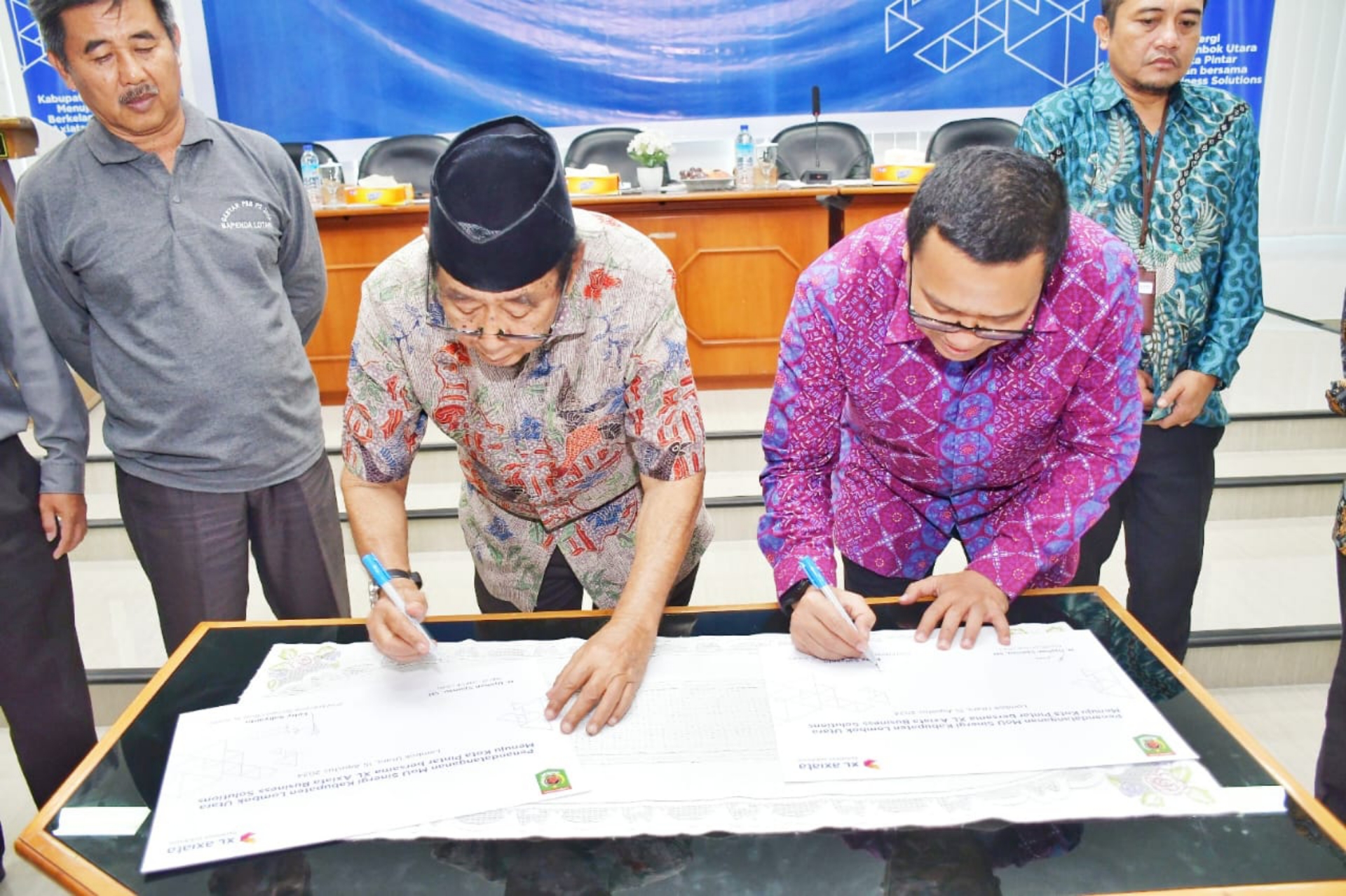 KERJA SAMA: Chief Enterprise Business Officer PT XL Axiata Feby Sallyanto (kanan) dan Bupati Lombok Utara H Djohan Sjamsu (kiri) menandatangani kerja sama pengembangan smart city. (IST/LOMBOK POST)