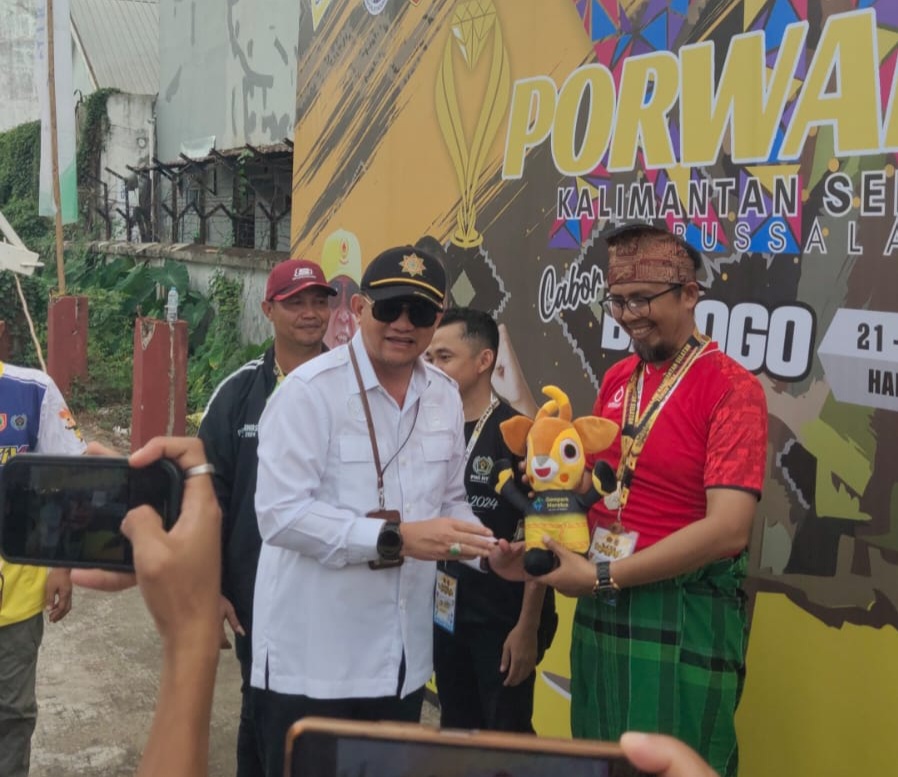 Kepala Dinas Dispora Kalimantan Selatan Hermansyah menyerahkan medali dan maskot Porwanas XIV kepada kapten tim balogo NTB Fajar Rahmat, Rabu (21/8).