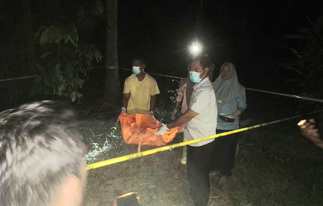DITEMUKAN TAK BERNYAWA: Anggota Polsek Gangga mengevakuasi mayat bayi yang ditemukan warga di salah satu kebun di Dusun Gondang Timur, Desa Gondang. (DOK POLRES LOTARA)