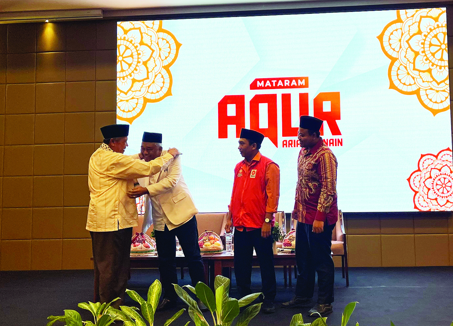 SIMBOLIK: TGH Achmad Muchlis memperbaiki kerah jas PKS yang dikenakan H Lalu Aria Dharma di acara silaturahmi bersama pelopor PKS kemarin (23/8). (ZAD/LOMBOK POST )