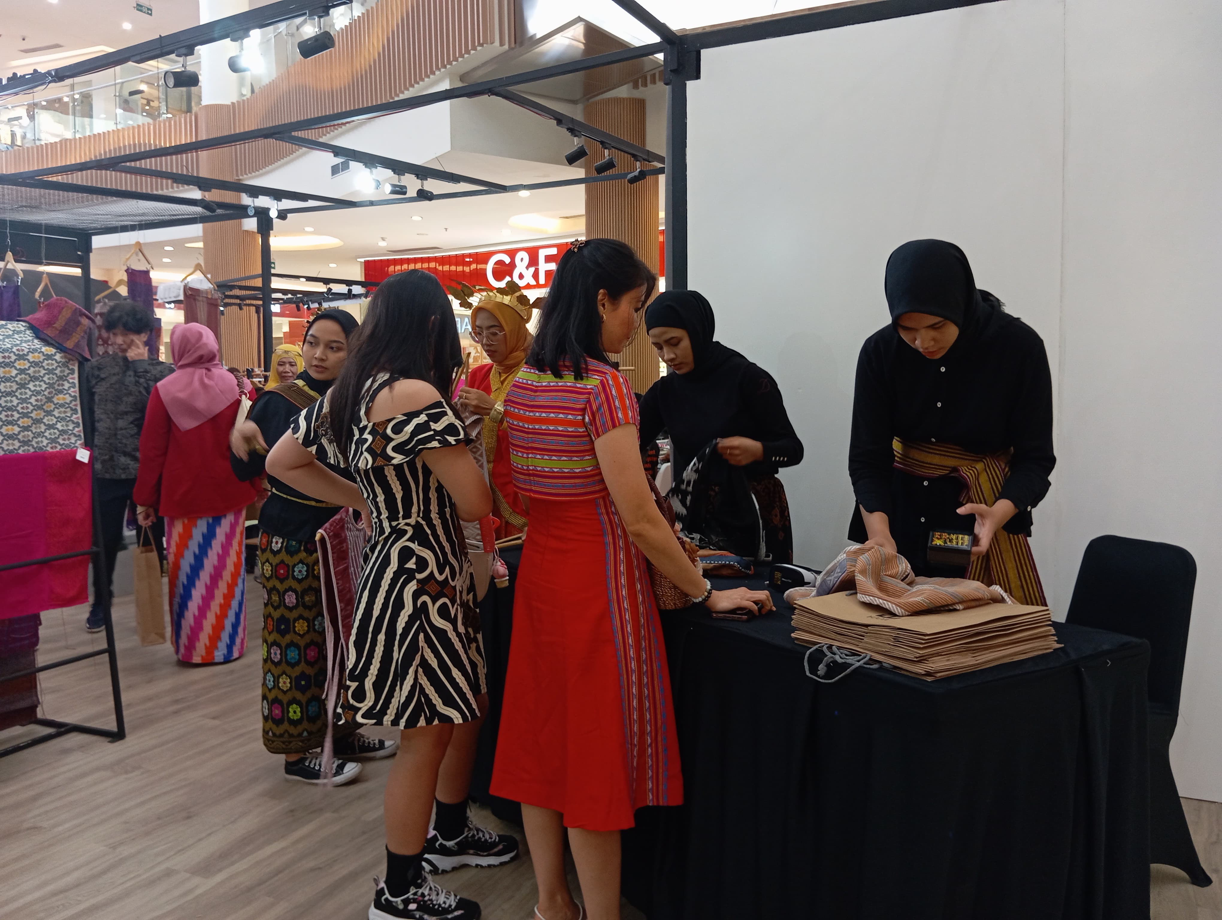 BELI PRODUK LOKAL: Sejumlah pengunjung yang membeli produk tenun di stan Moda Entebe, dalam kegiatan KK-NTB x LSTF 2024, di atrium Lombok Epicentrum Mall, Sabtu (24/8).(FERIAL/LOMBOK POST)