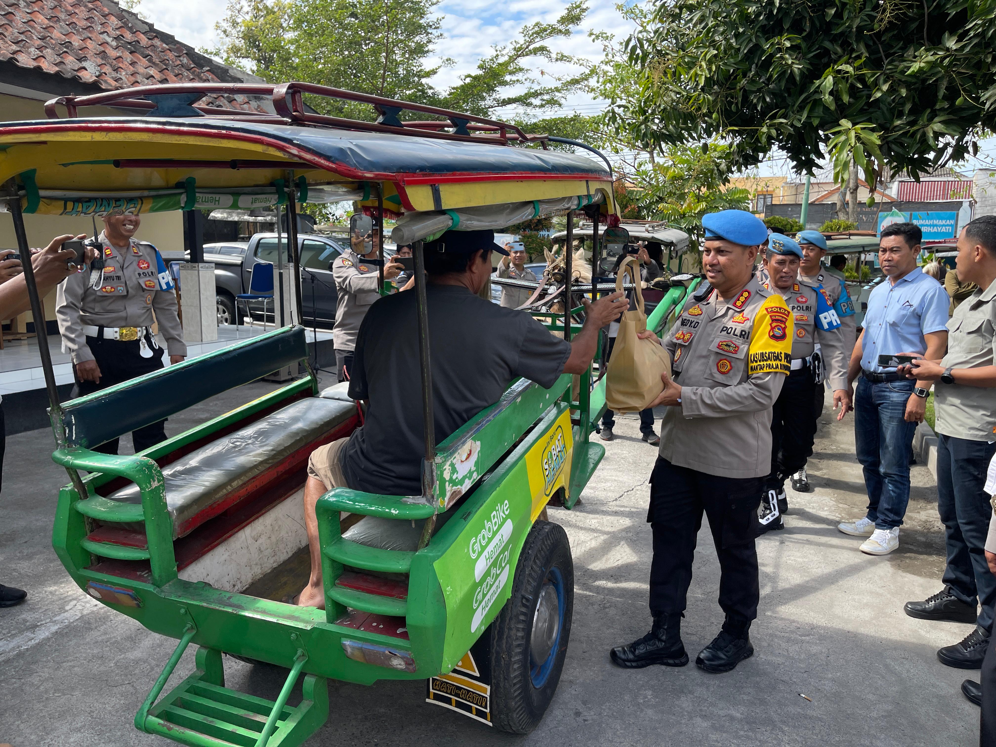 Kabidpropam Polda NTB Kombespol Dedy Darmawansyah memberikan paket sembako kepada salah satu kusir cidomo di Pasar Pagutan, Mataram, Rabu (28/8).