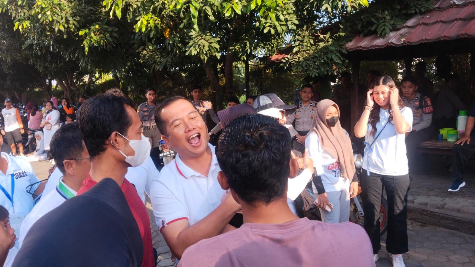 HANGAT PADA ANAK-ANAK: Bacagub NTB Lalu Muhamad Iqbal menyempatkan diri menyapa masyarakat dengan menggendong seorang balita di halaman kantor Lombok Post menuju GOR Turida Mataram, Minggu (15/9).