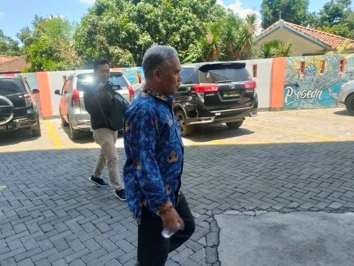 PENUHI PANGGILAN JAKSA: Kepala Bappeda NTB Iswandi berjalan di parkiran kantor Kejati NTB usai diperiksa terkait dugaan korupsi dana jaminan pembangunan NCC, Selasa (17/9). (Suharli/Lombok Post)