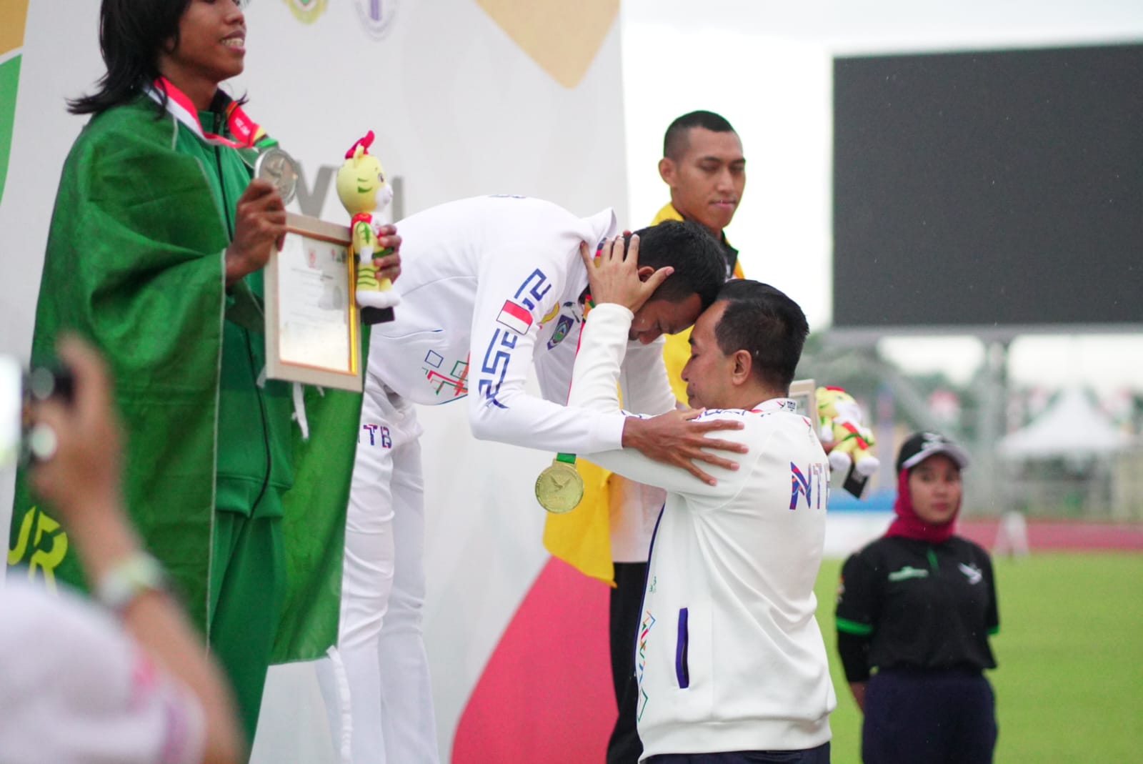 Ketua KONI NTB Mori Hanafi memberikan selamat kepada Sapwaturrahman setelah meraih medali emas nomor lompat jangkit.