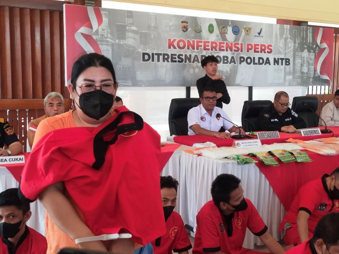 DIBORGOL: Bos mushroom berinisial IA diborgol polisi saat pres rilis di Polda NTB, Rabu (18/9). (Harli/Lombok Post)