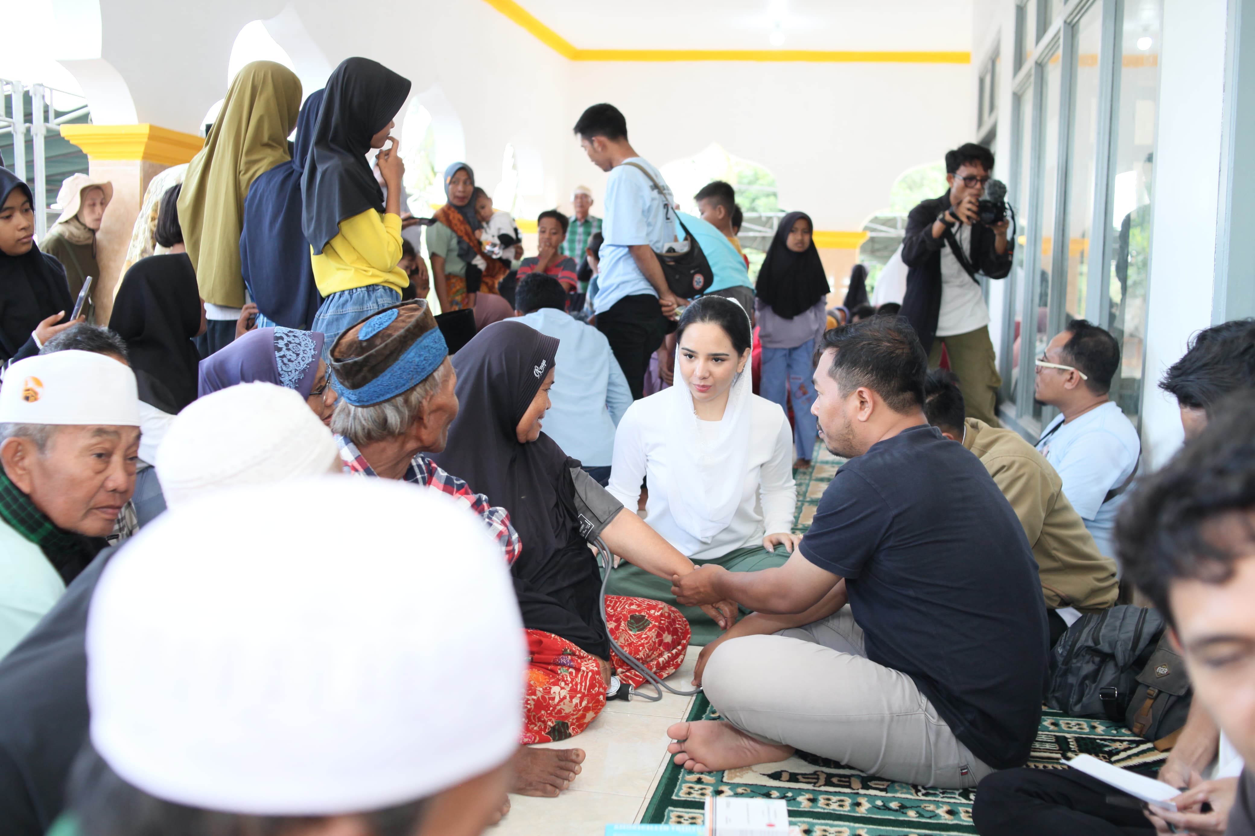 Ketua Yayasan HBK Peduli Rannya Agustyra Kristiono berdialog dengan warga saat pengobatan dan sunatan masal gratis di Dusun Pelepok, Desa Lepak, Kecamatan Sakra Timur, Kabupaten Lombok Timur.