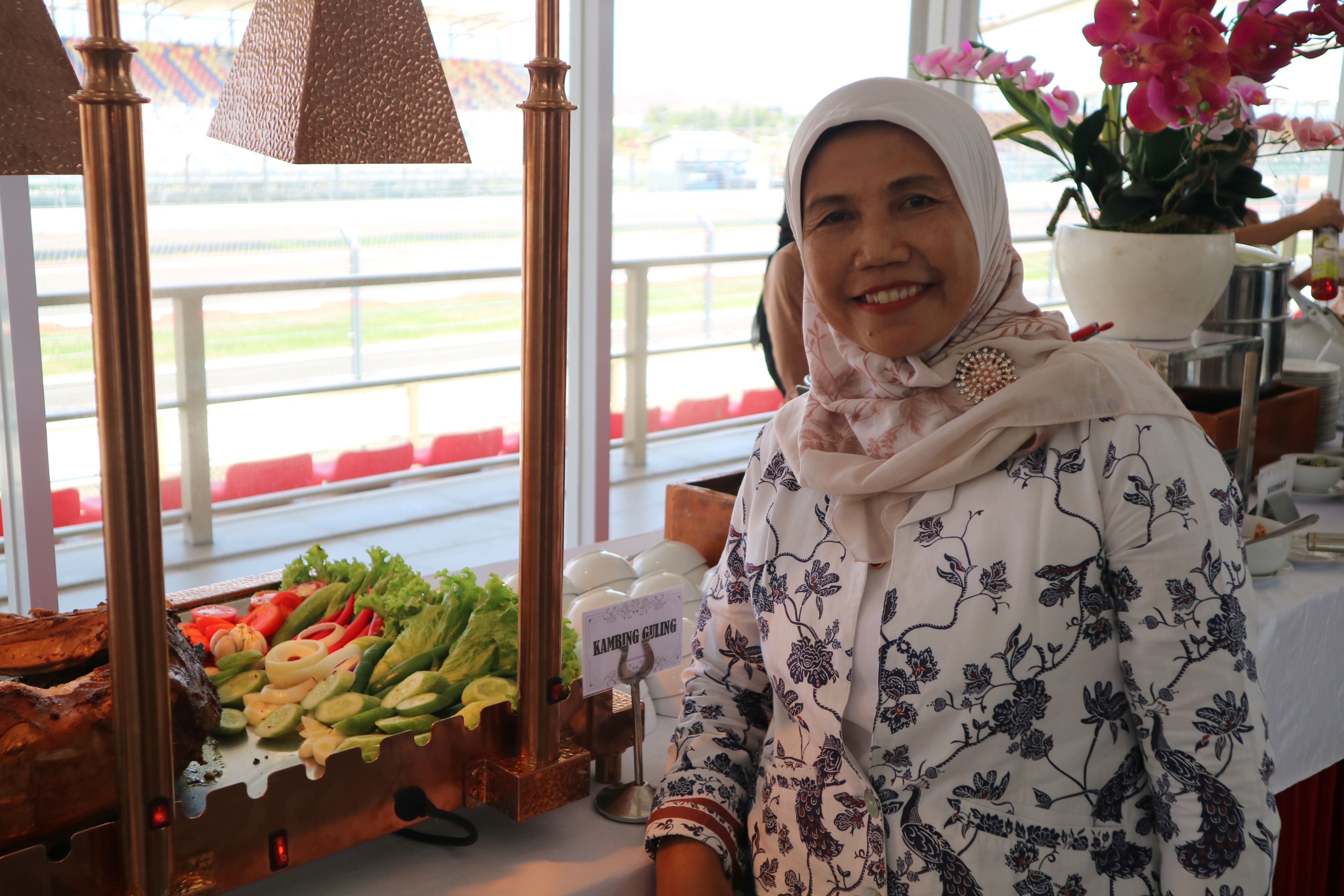 Wagini owner Bu Kus Katering berfoto dengan aneka menu makanan yang disajikan di ruang VIP Deluxe, Sirkuit Internasional Mandalika, Kamis (19/9).