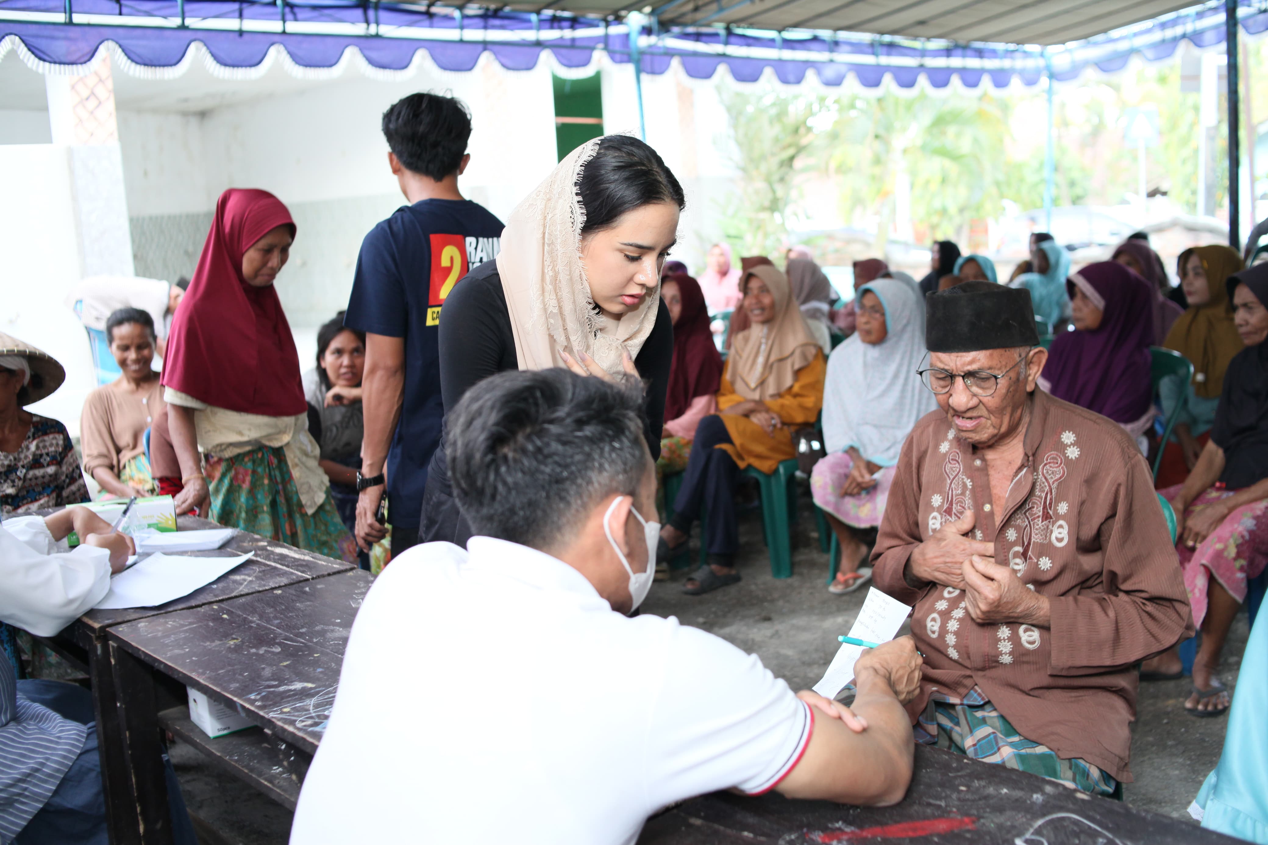 Ketua Yayasan HBK Peduli Rannya Agustyra Kristino berbincang dengan warga saat bakti sosial Yayasan HBK Peduli di Desa Sengkol, Kecamatan Pujut, Kabupaten Lombok Tengah, Jumat (20/9).