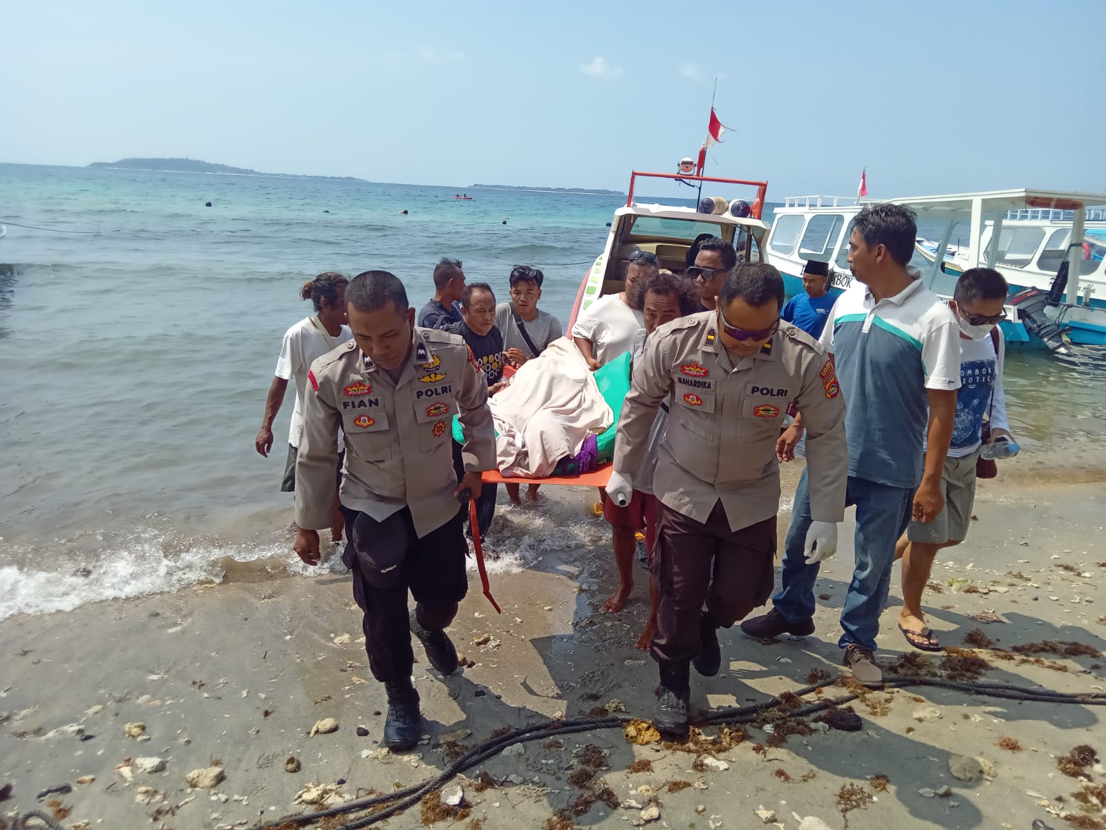 EVAKUASI: Anggota Polsek Pemenang bersama warga evakuasi korban meninggal di Gili Trawangan, Sabtu (28/9). (POLRES LOTARA FOR LOMBOK POST)