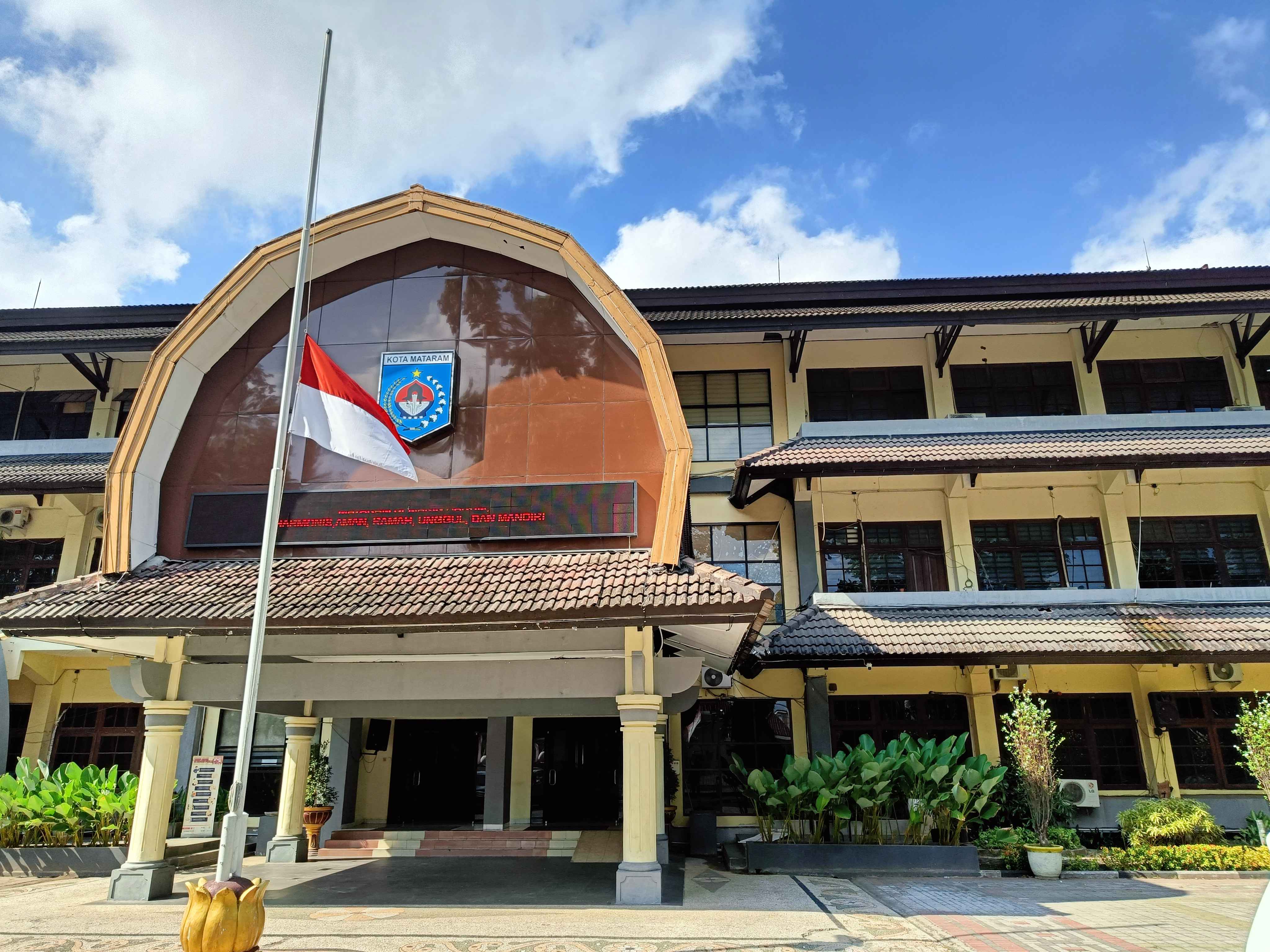 BERKABUNG: Bendera setengah tiang dikibarkan di kantor Pemkot Mataram, Senin (30/9). (ZAD/LombokPost)
