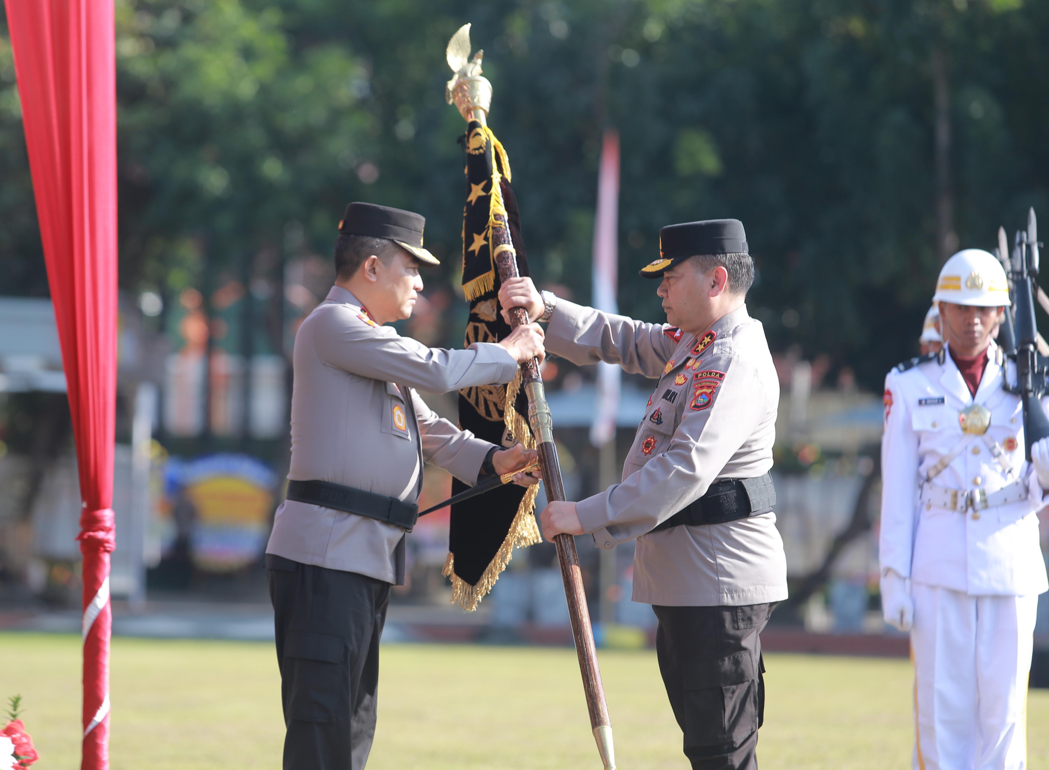 Irjen Pol Umar Faroq (kanan) menyerahkan pataka kapolda NTB kepada Irjen Pol Hadi Gunawan dalam upacara di Lapangan Bhara Daksa Polda NTB, Rabu (2/10).
