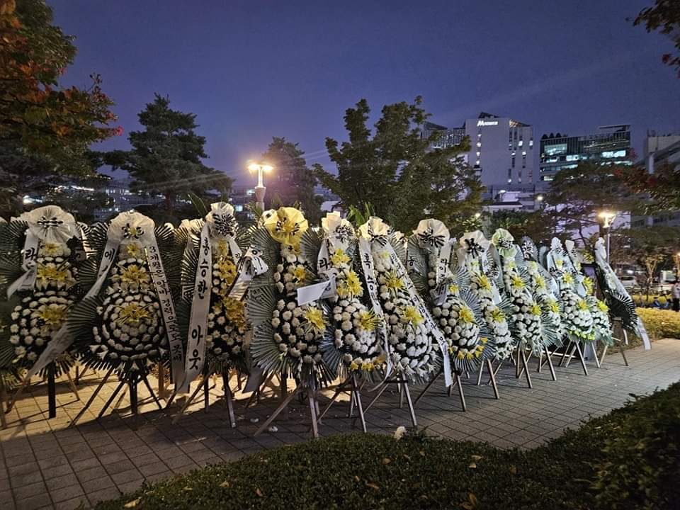 Puluhan karangan bunga pemakaman yang dikirimkan penggemar RIIZE ke depan gedung SM Entertainment.