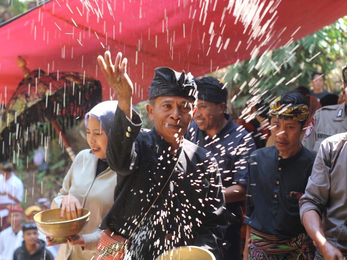 MENABUR SESAJEN: Salah seorang tokoh adat menabur beras di atas mata air di Desa Montong Betok. (Supardi/Lombok Post)