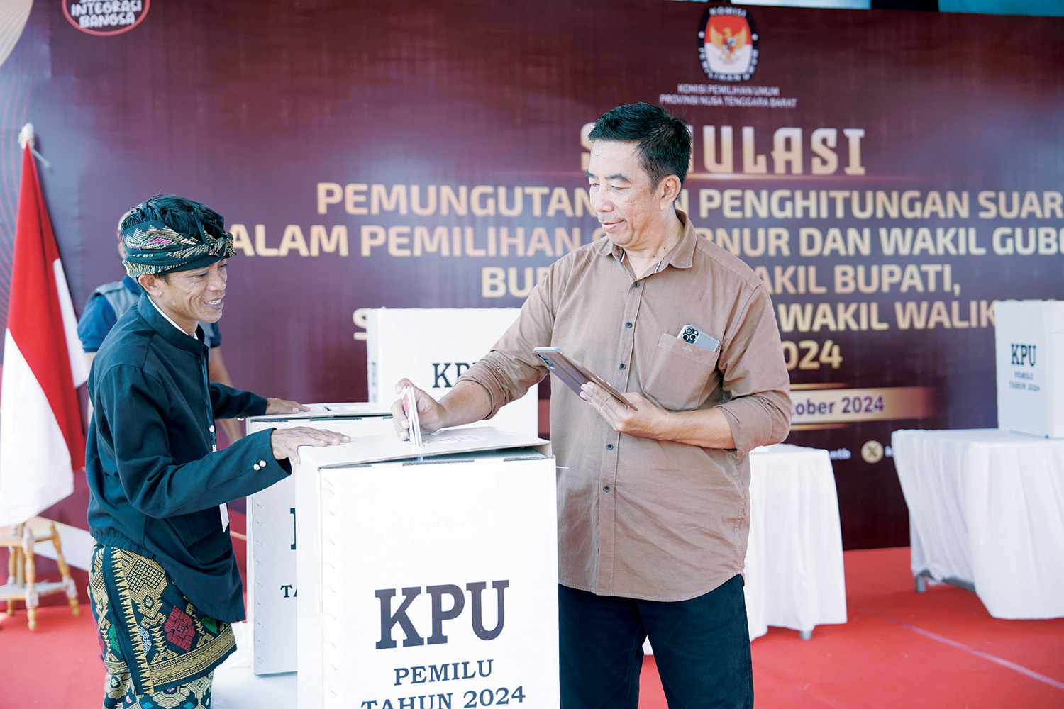 Seorang pemilih memasukkan surat suara yang sudah dicoblos ke kotak suara dalam kegiatan simulasi.