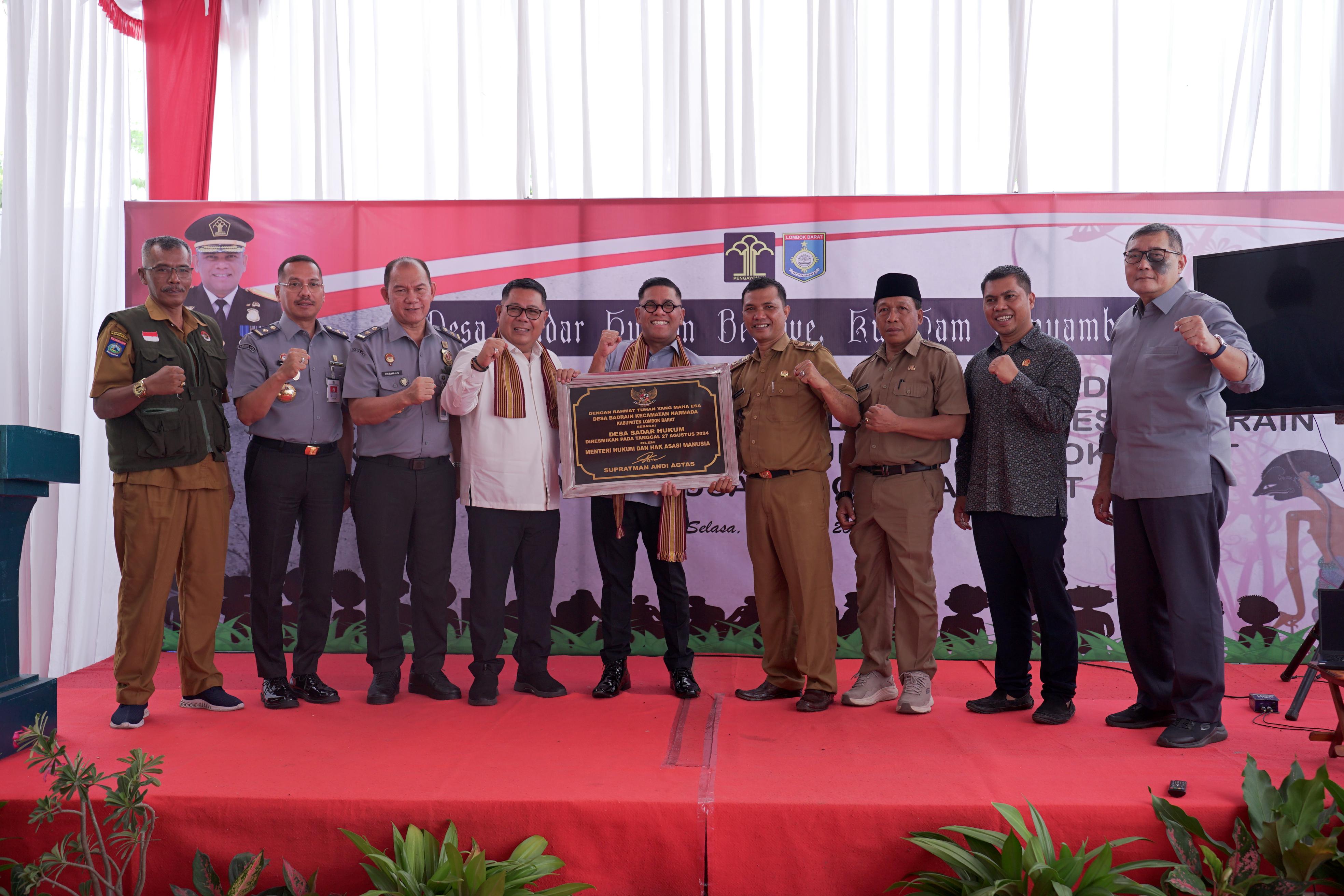 SIMBOLIS: Kakanwil Kemenkumham NTB Parlindungan menyerahkan prasasti Desa Sadar Hukum kepada Kepala Desa Badrain, Kecamatan Narmada, Lombok Barat Romi Purwandi, Selasa (15/10).