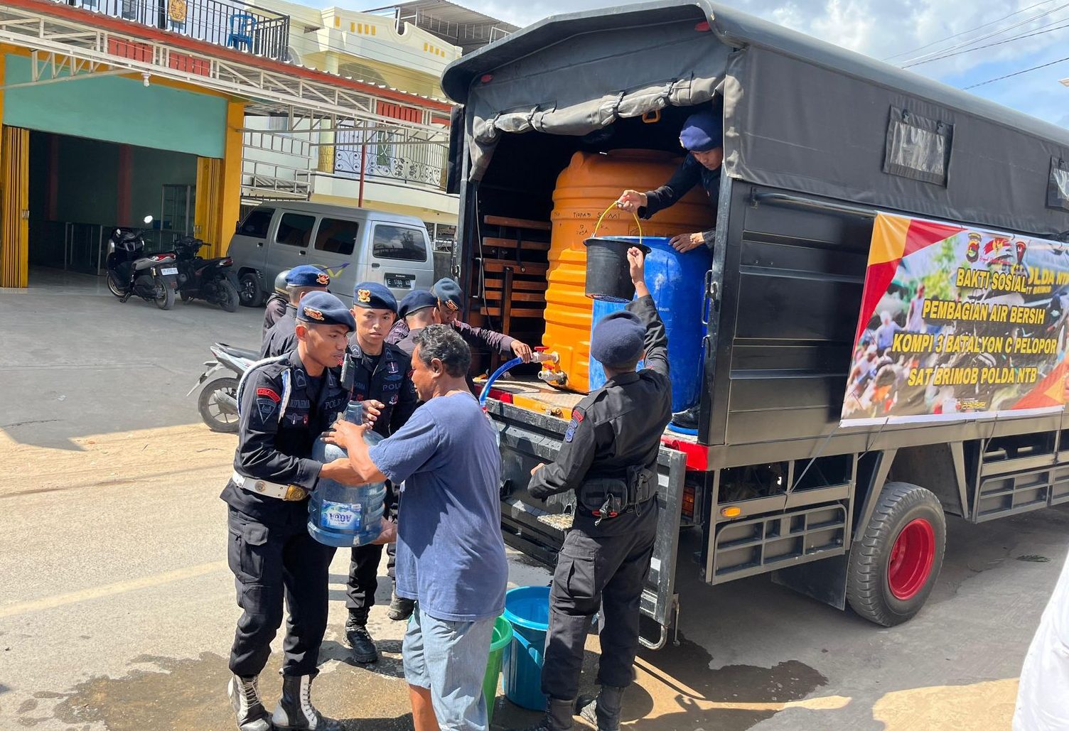 SALURKAN AIR BERSIH: Anggota Batalyon C Pelopor Satuan Brimob Polda NTB menyalurkan air bersih kepada warga terdampak kekeringan, Rabu (16/10).