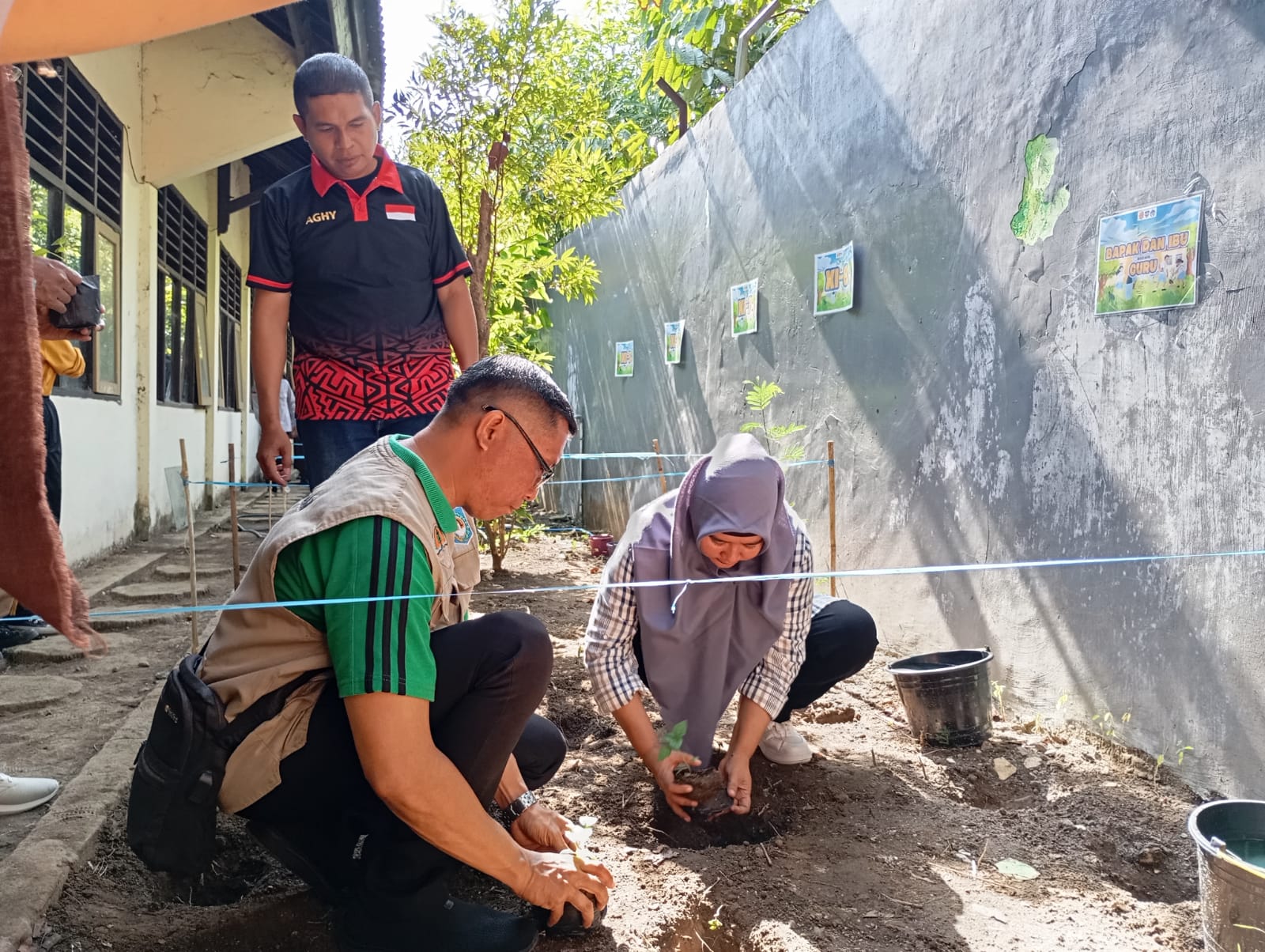 JAGA LINGKUNGAN: Plt Kepala SMAN 3 Mataram Yuspita Martiningrum bersama pihak DLH Kota Mataram menanam cabai di halaman belakang sekolah setempat, Sabtu (19/10) lalu. (Ali Rojai/Lombok Post)
