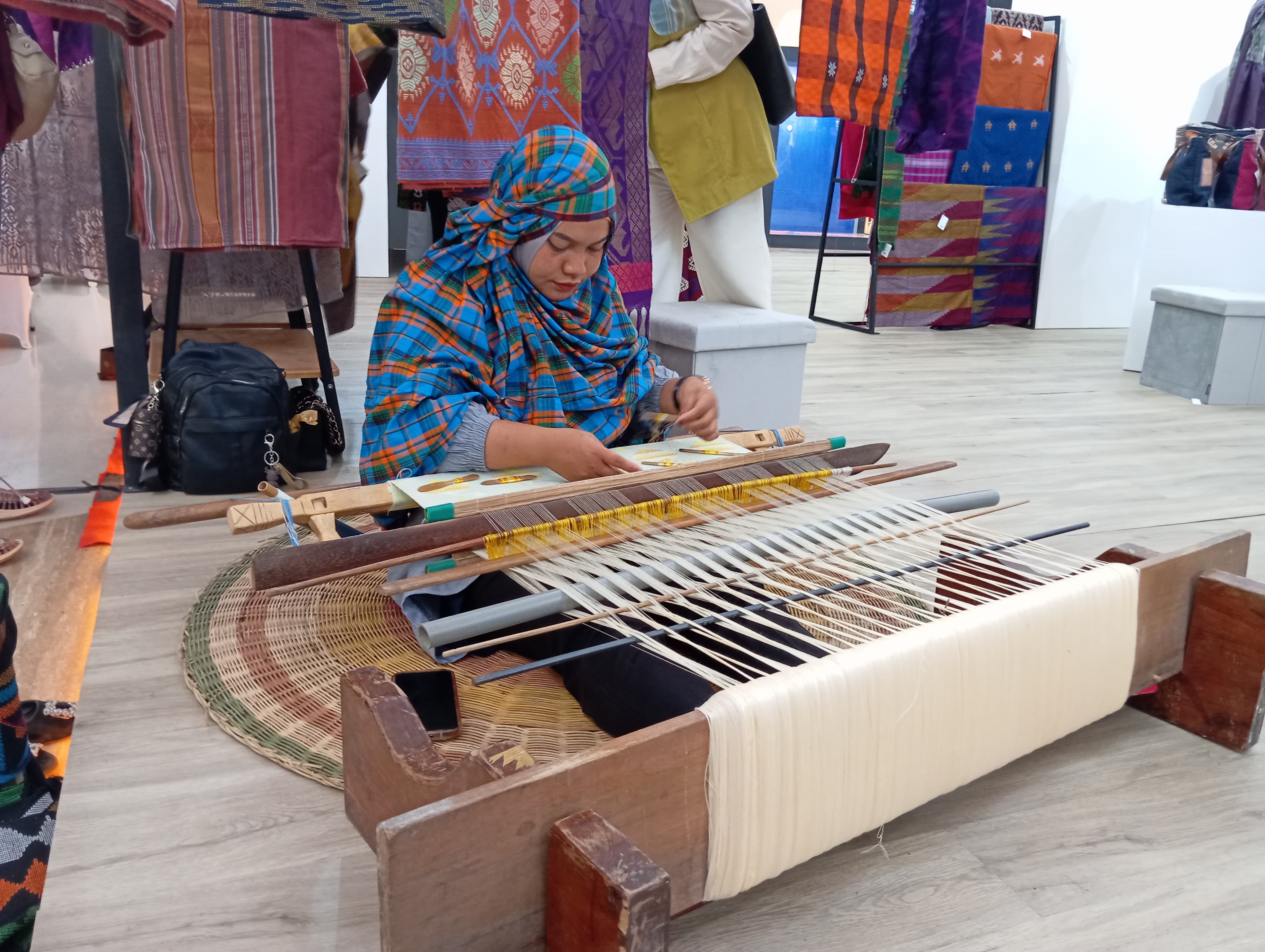 MENENUN LANGSUNG: Salah satu penenun asal Dompu yang menenun langsung kain tenun Muna Pa&rsquo;a dalam kegiatan pameran Dekranasda NTB dan Bank Indonesia, di Lombok Epicentrum Mall, beberapa waktu lalu.