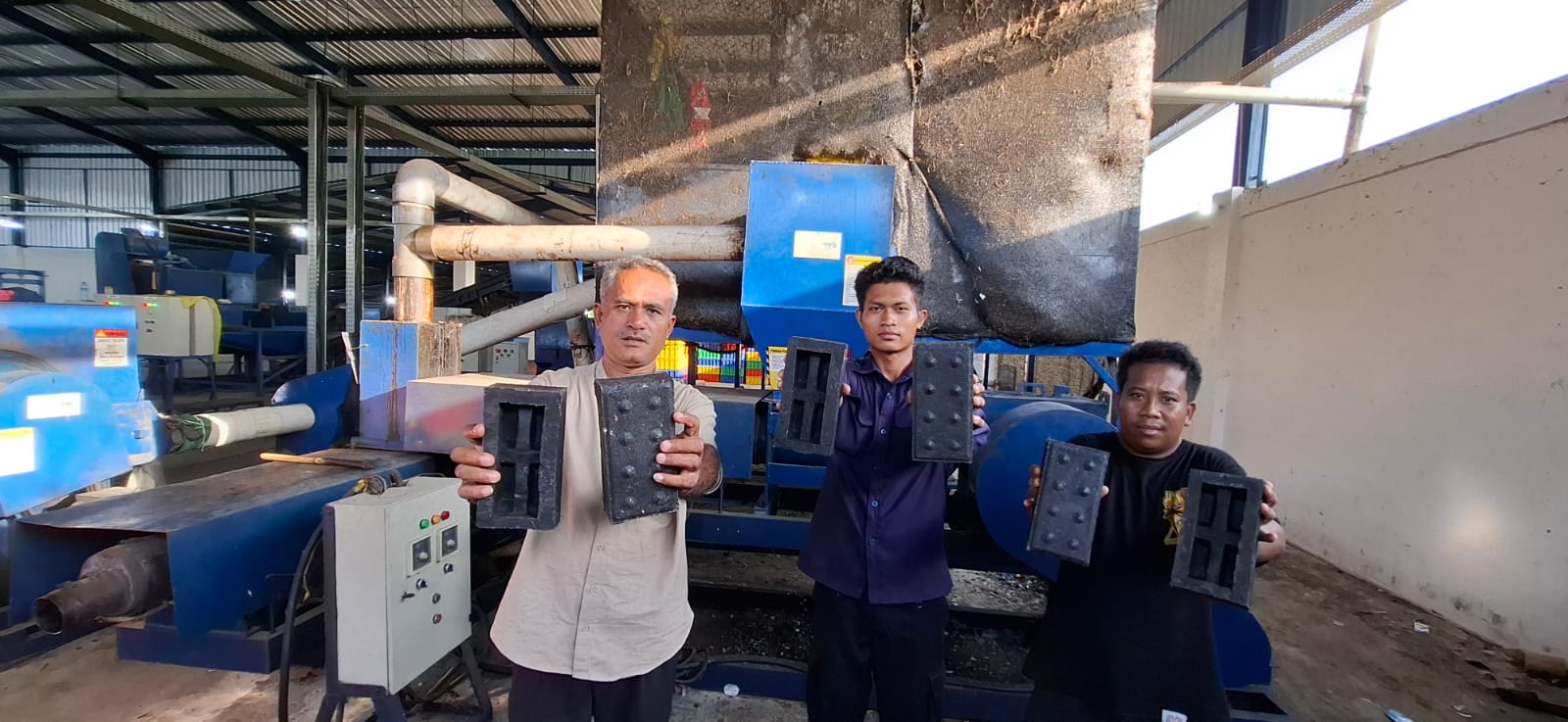 Koordinator TPST Sandubaya Kamarudin (kiri) menunjukkan paving blok dari sampah plastik hasil olahan TPST Sandubaya, kemarin (23/10).