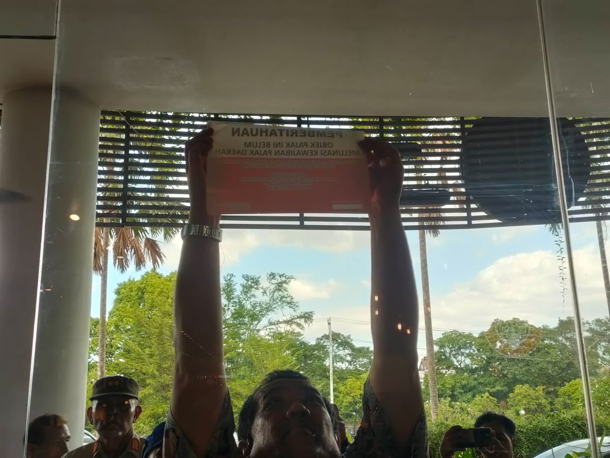 BERIKAN EFEK JERA: Seorang petugas menempelkan stiker tanda belum bayar pajak di salah satu tempat usaha, beberapa waktu lalu.