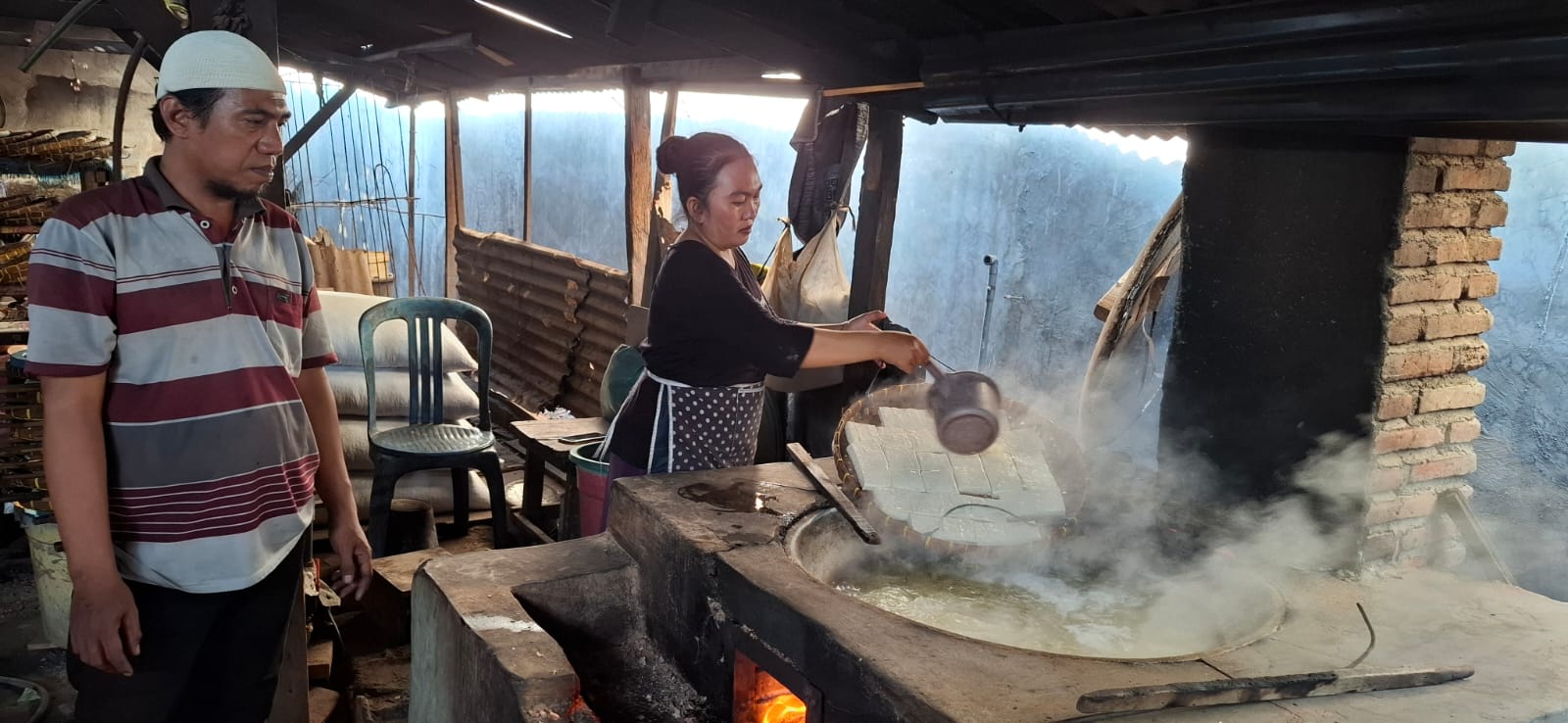 BUTUH AIR: Rabiatun Hasanah seorang produsen tahu sedang memasak tahu di gudang rumahnya di Lingkungan Karang Pelambik, Kelurahan Abian Tubuh Baru, Jumat (25/10).