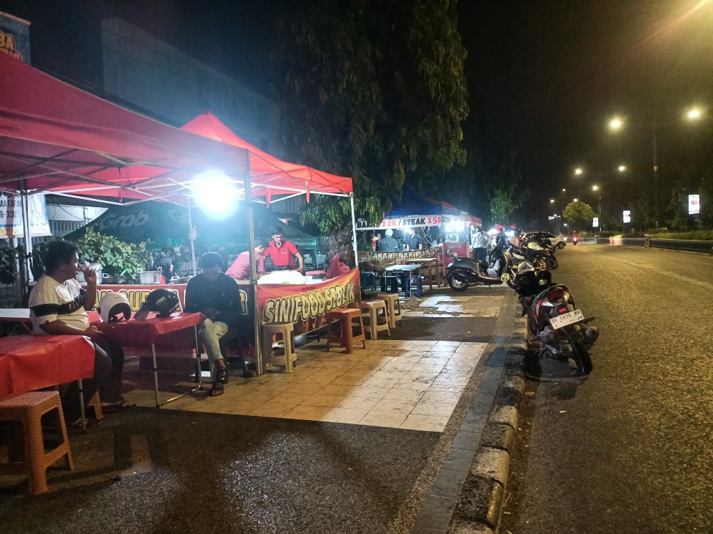 TIDAK PATUH: Sejumlah pedagang di depan Eks Bandara Selaparang memanfaatkan trotoar sebagai tempat jualan, tadi malam.