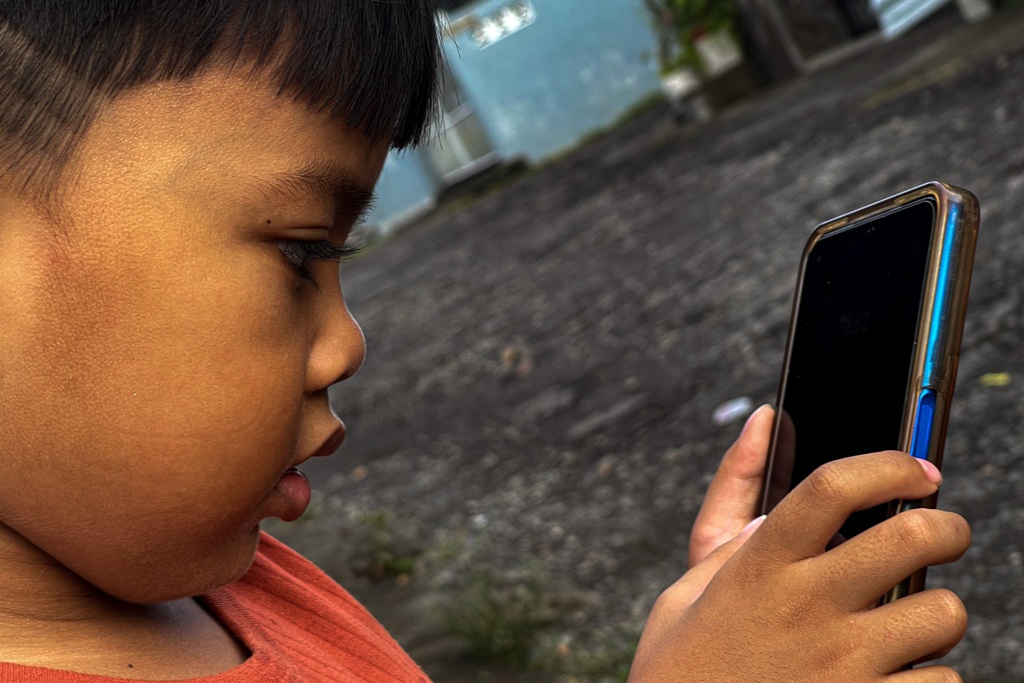ILUSTRASI: Seorang anak tengah memainkan smartphone tanpa pengawasan orang tua.