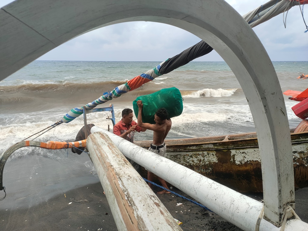 HINDARI MELAUT: Seorang nelayan merapikan peralatan melautnya saat terjadi angin kencang di kawasan pesisir pantai Ampenan, beberapa waktu lalu.