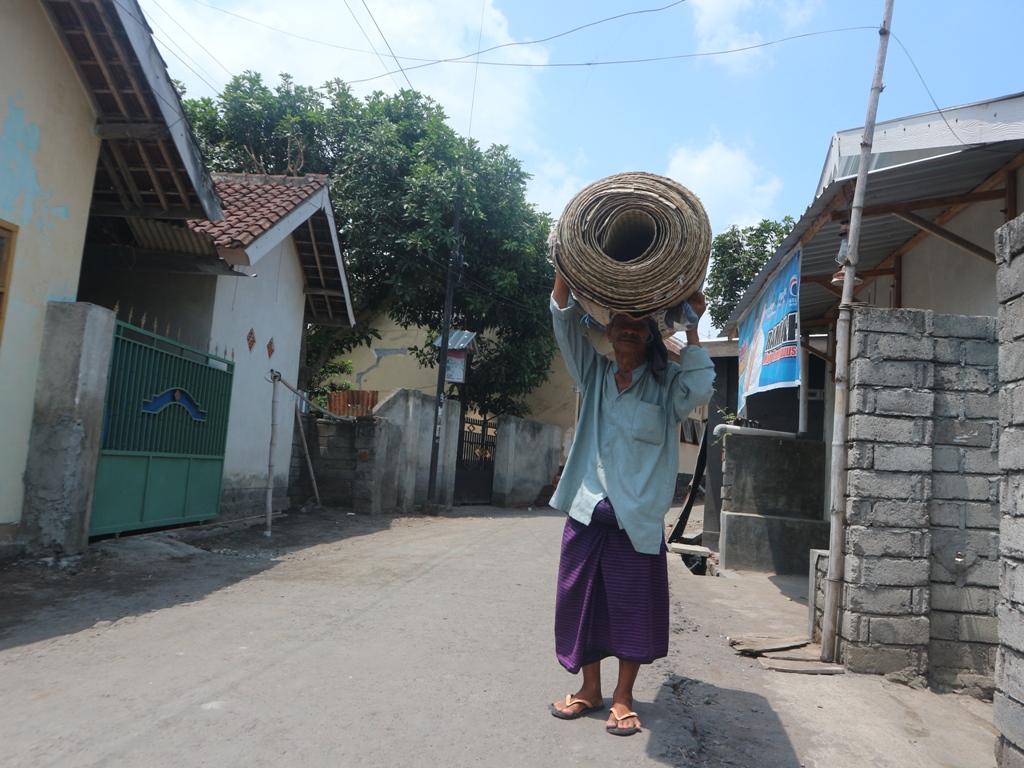 MENCARI REZEKI: Hariyono, penjual tikar pandan keliling berjalan kaki menawarkan dagangannya ke masyarakat di Desa Kabar, Kecamatan Sakra, Lombok Timur (Lotim), Rabu (13/11). SUPARDI/LOMBOK POST