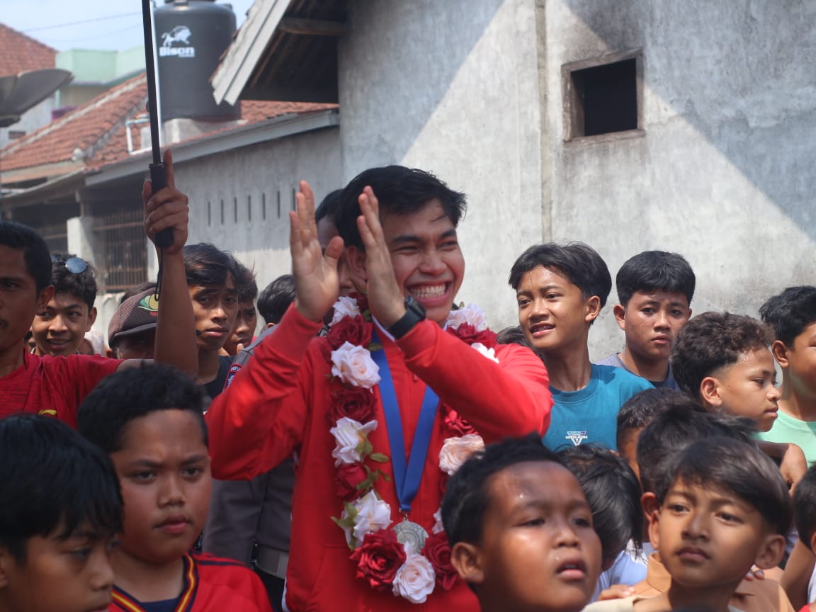 SAMBUT: Ribuan masyarakat Desa Selagik, Kecamatan Terara Lombok Timur saat menyambut kepulangan Romi Humandri Timnas Futsal Indonesia yang berhasil meraih juara AFF Futsal 2024. SUPARDI/LOMBOK POST