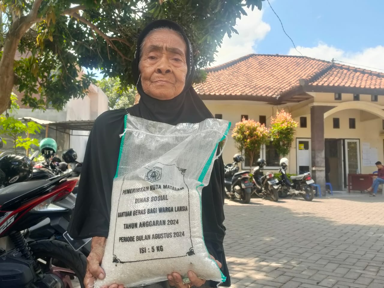 Seorang nenek menerima pembagian bansos beras, beberapa waktu lalu. (HARLI/LOMBOK POST)