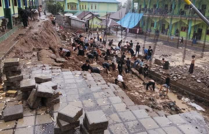 LONGSOR: Sejumlah relawan membersihkan tanah longsor di halaman Pondok Pesantren (Ponpes) Alquran Nurul Hidayah Lekoq Lendang Andus Lembar, Selasa (19/11). UMAR/LOMBOK POST