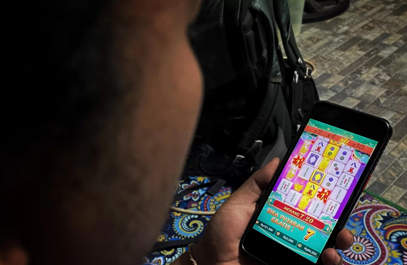 MASIH SAJA AKTIF: Seorang warga bermain judi online jenis Slot melalui handphone-nya, beberapa waktu lalu. ILUSTRASI LOMBOK POST